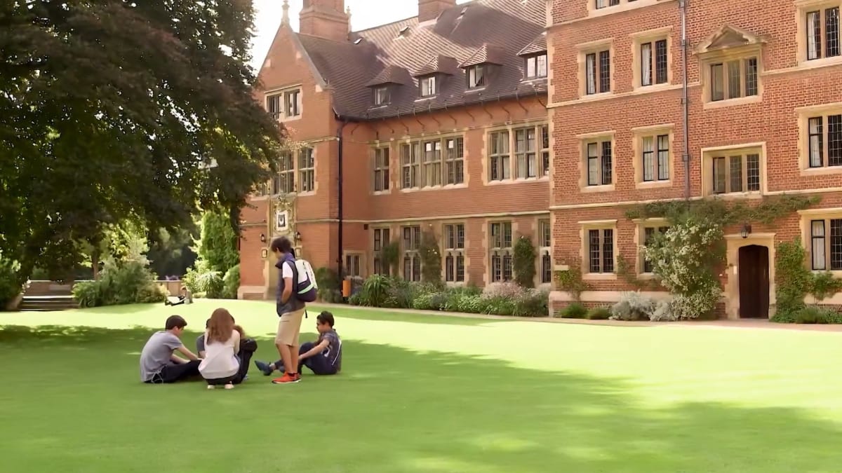 Students gather on a Cambridge college lawn.
