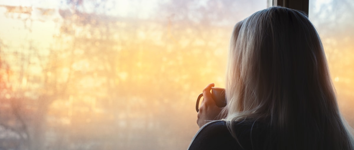 Photo of someone looking out of a window