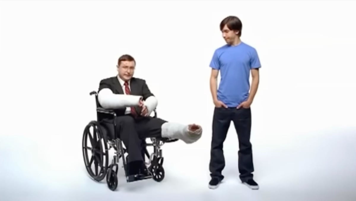 Still from the Get a Mac MagSafe ad showing the PC character lying on the floor after being pulled off his desk by a tripped power cord.