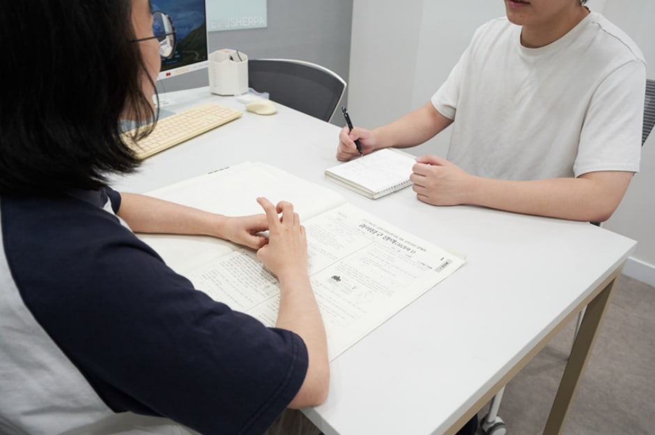 학생과 멘토가 대면 상담하며 학습 내용을 확인하는 모습