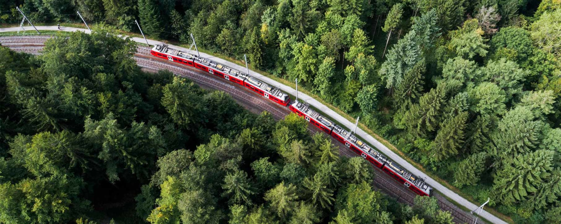 cosmofunding – Vontobel's financing platform on path to growth. A red train drives through a forest.