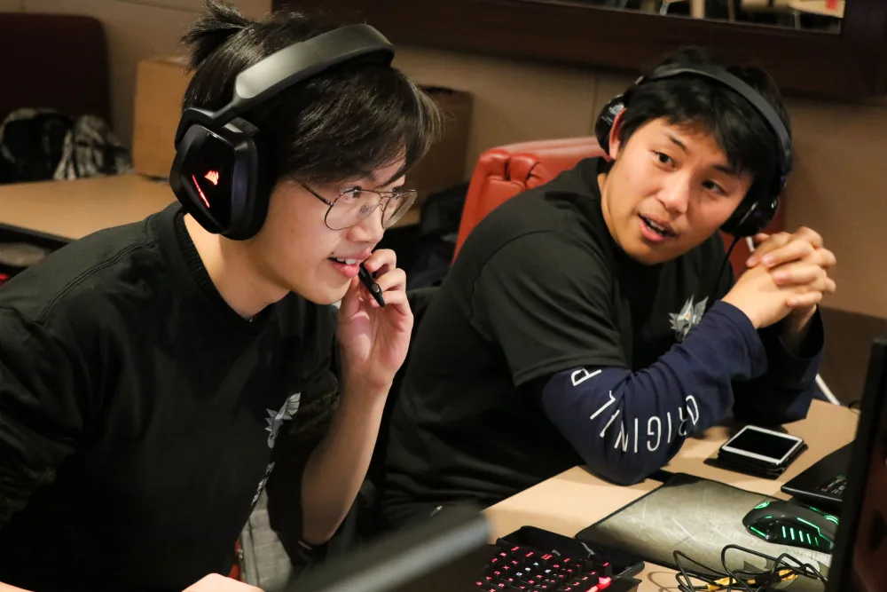Two students in Corsair headphones, hosting a gaming event.