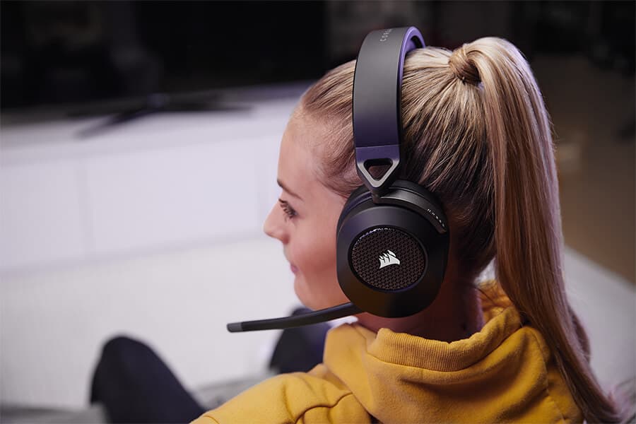 A female gamer relaxing while wearing the black HS65 WIRELESS gaming headset.