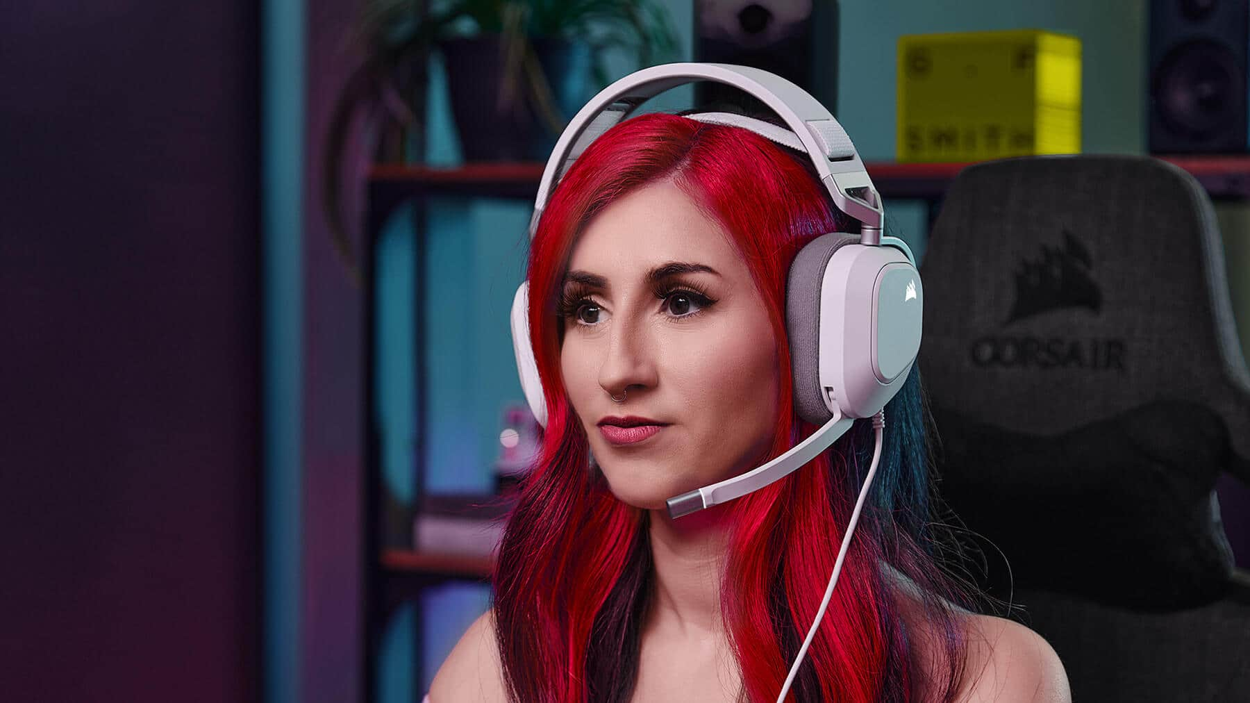 A woman with her hair tied back looks straight forward wearing HS80 RGB USB headphones, showing off the comfortable floating headband design.