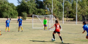 Girls football team kicking goals