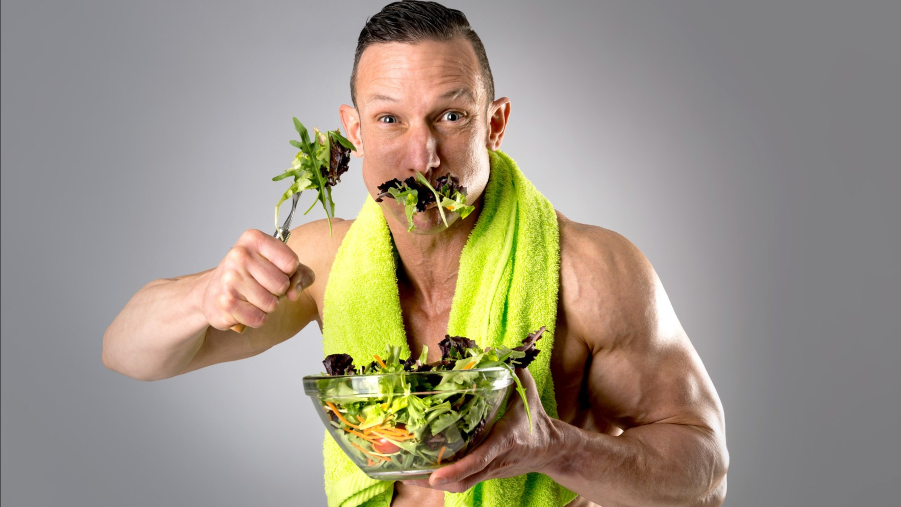 Der sportliche Mann stopft sich Salat in den Mund. | Spiele.de