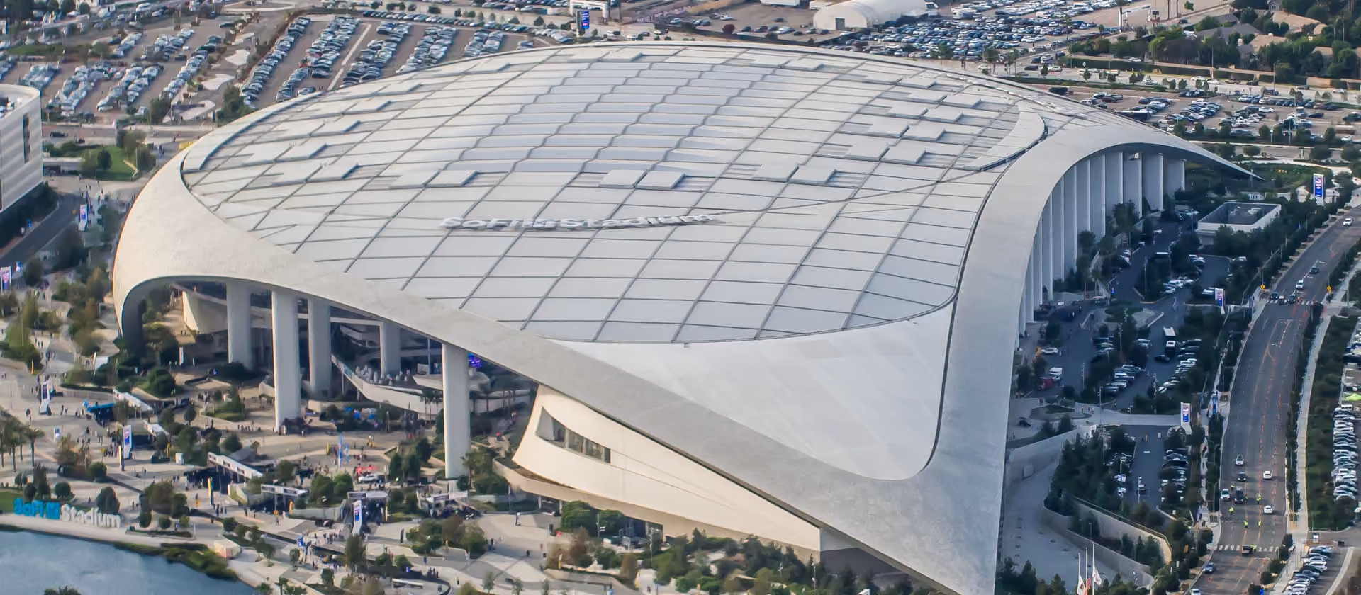 Luftaufnahme des SoFi Stadium in Inglewood mit Parkplätzen und umliegenden Straßen.