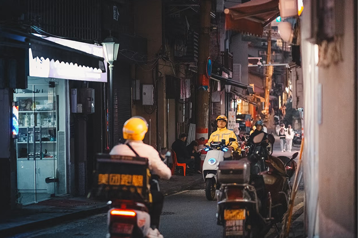 Delivery scooters in a lit alley