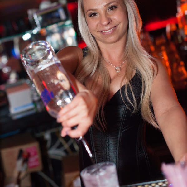 Beautiful bartender pouring drinks