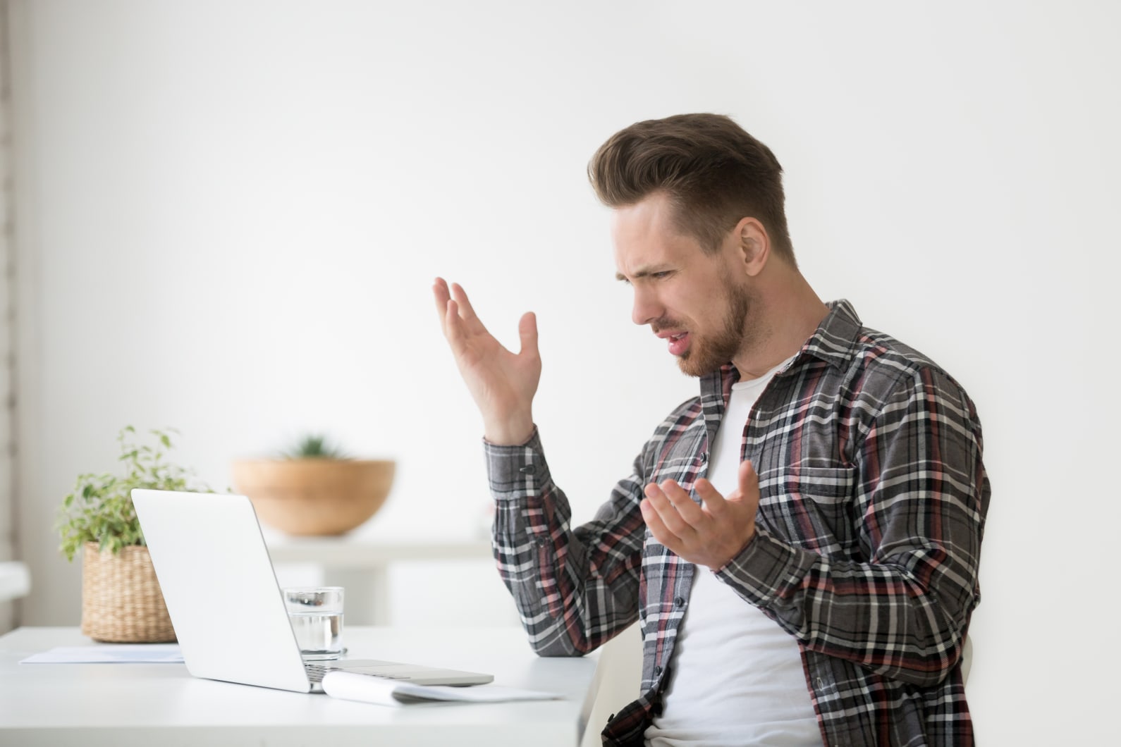 Person appearing frustrated with something on laptop screen