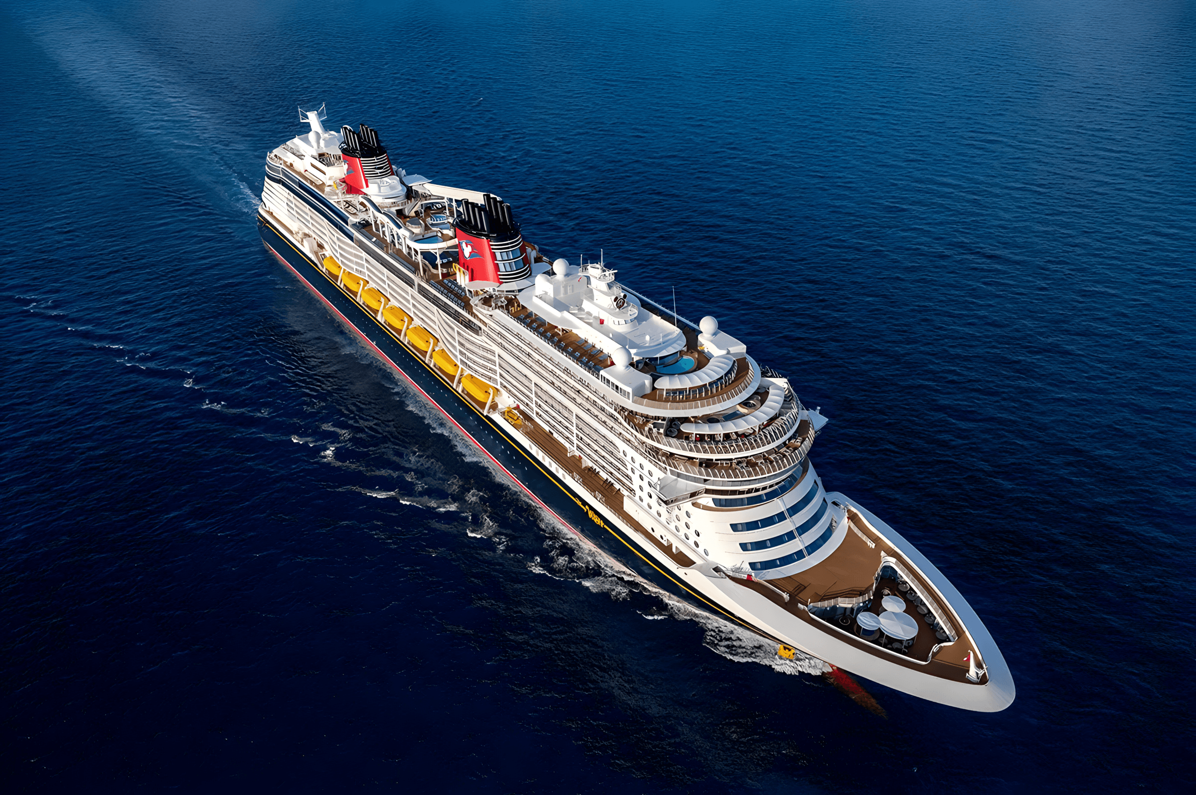 Aerial view of the Disney Wish cruise ship sailing in blue waters