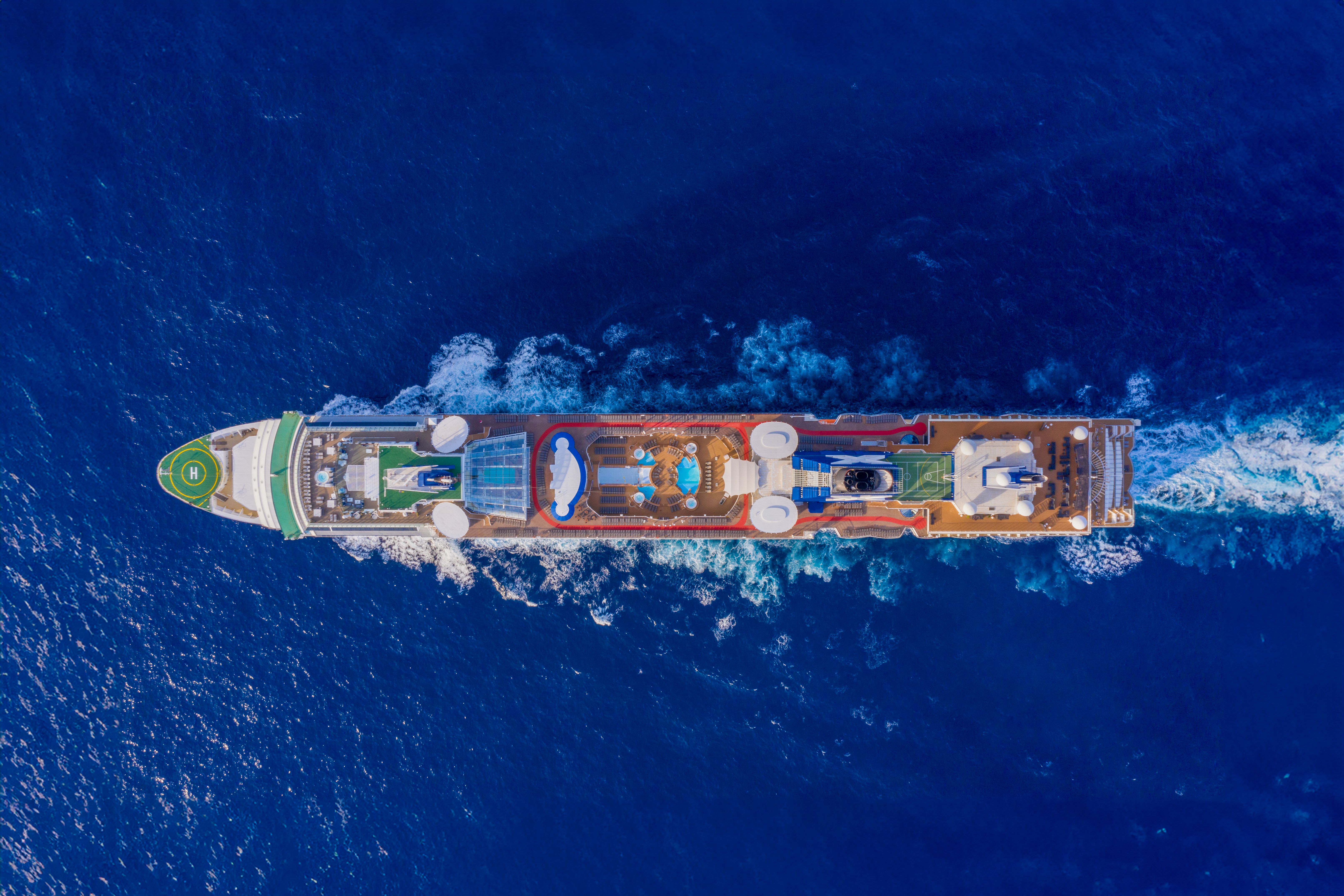 Aerial view of Celebrity Summit cruise ship at sea, showcasing onboard amenities and the vast ocean.