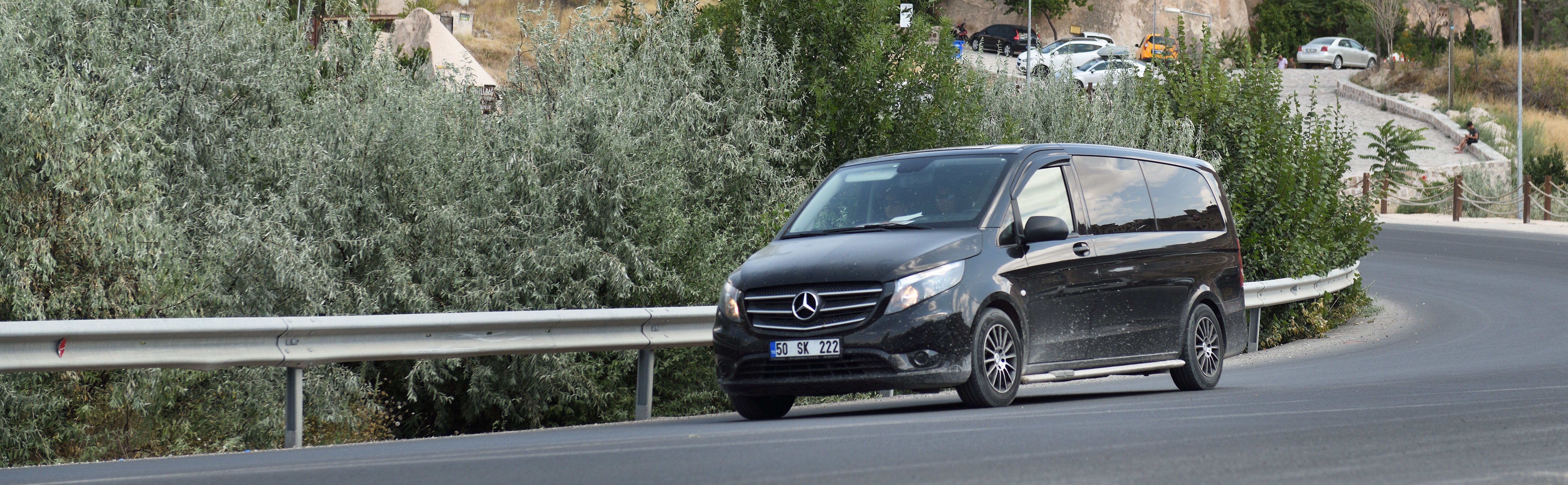 Mercedes shuttle van on the road providing group transport to the cruise terminal, blending convenience with luxury travel.