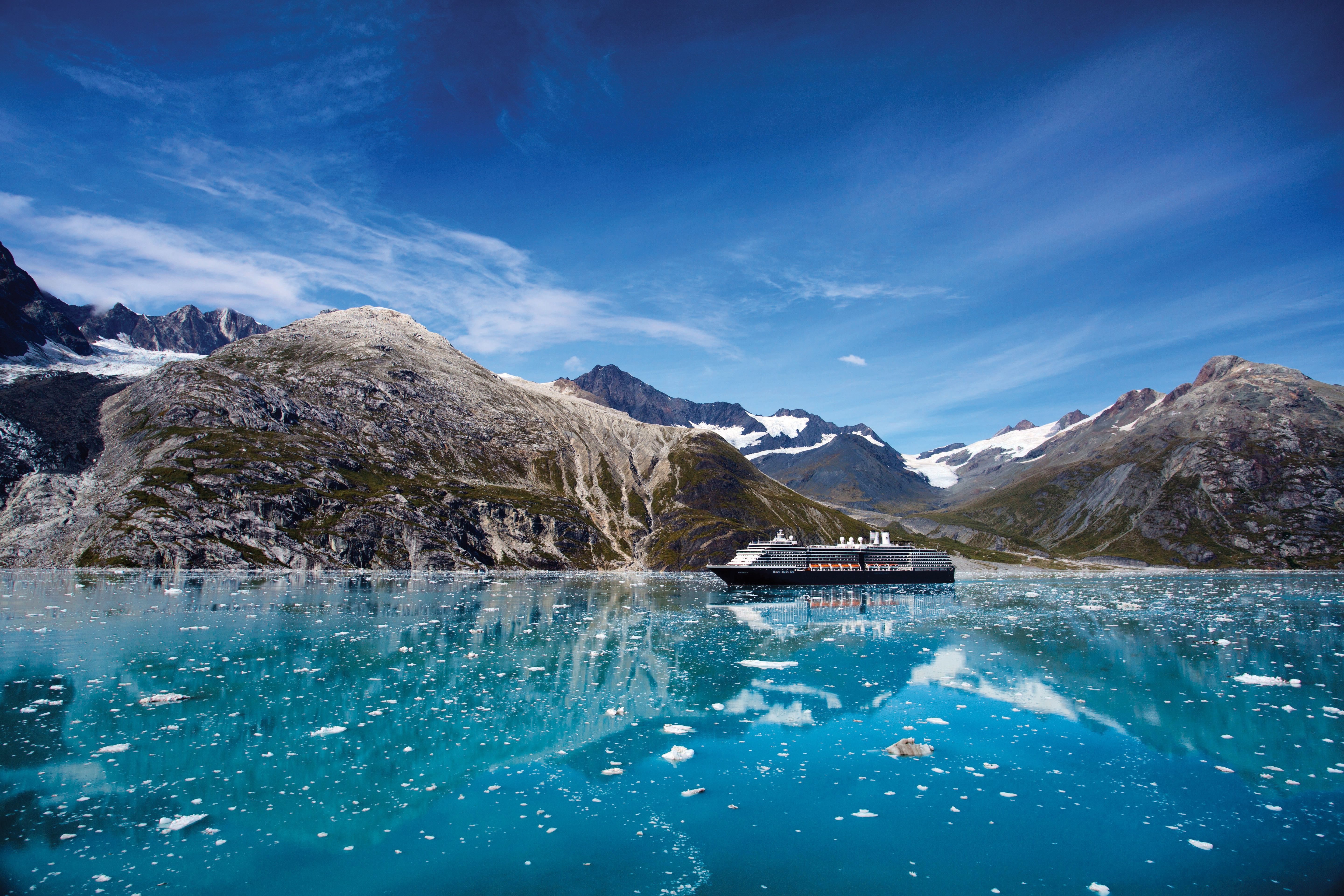 Holland America's Westerdam cruising Glacier Bay, Alaska with icebergs and mountains.