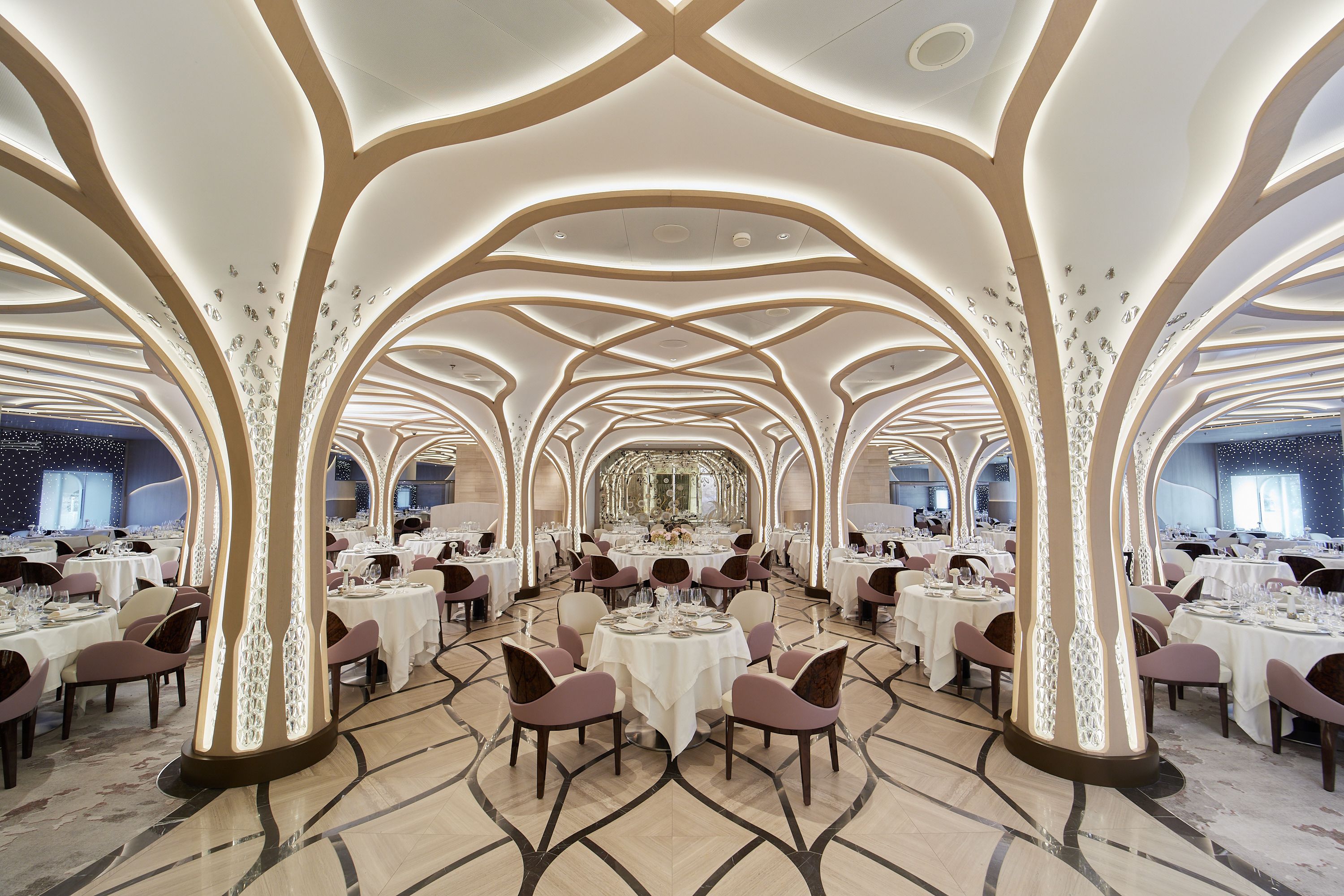 Regent's Grandeur Compass Rose Restaurant with elegant tree-like pillars and sophisticated dining setup.