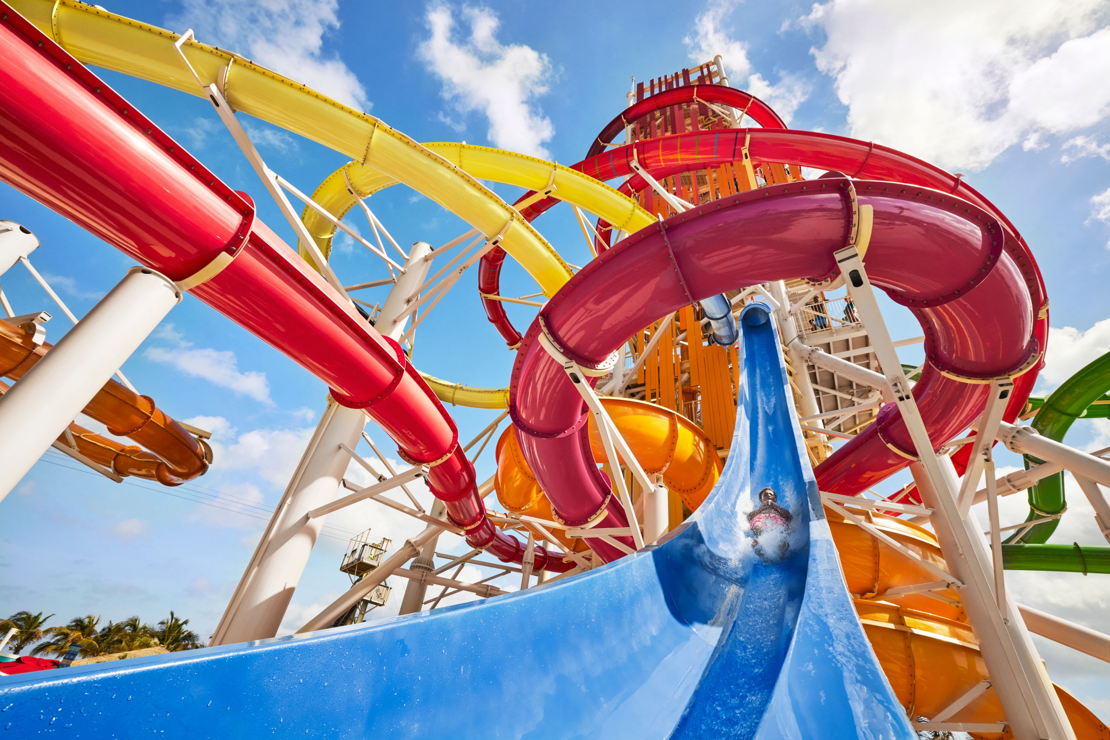 Thrilling water slide tower on Royal Caribbean's deck under a bright blue sky.