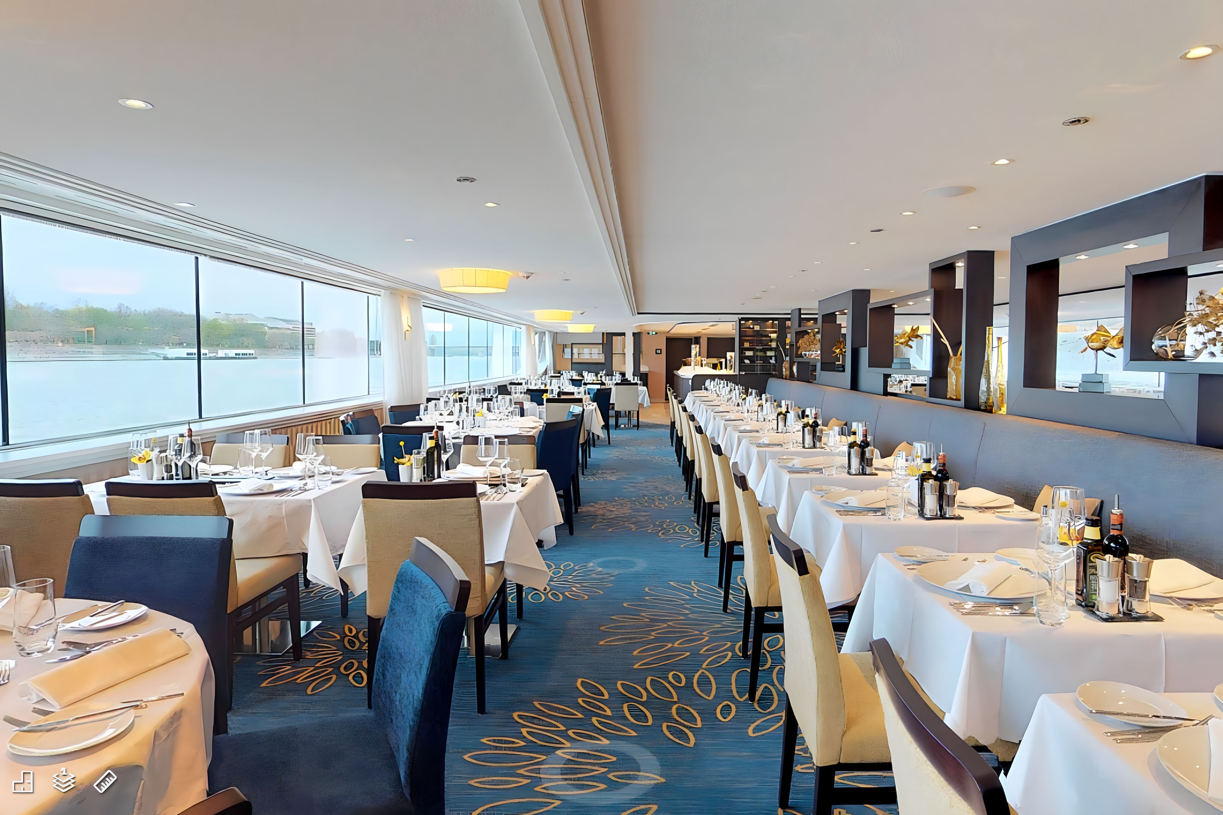Sophisticated Panorama Dining Room on Avalon Waterways, with tastefully set tables and large windows, inviting guests to dine with a view.