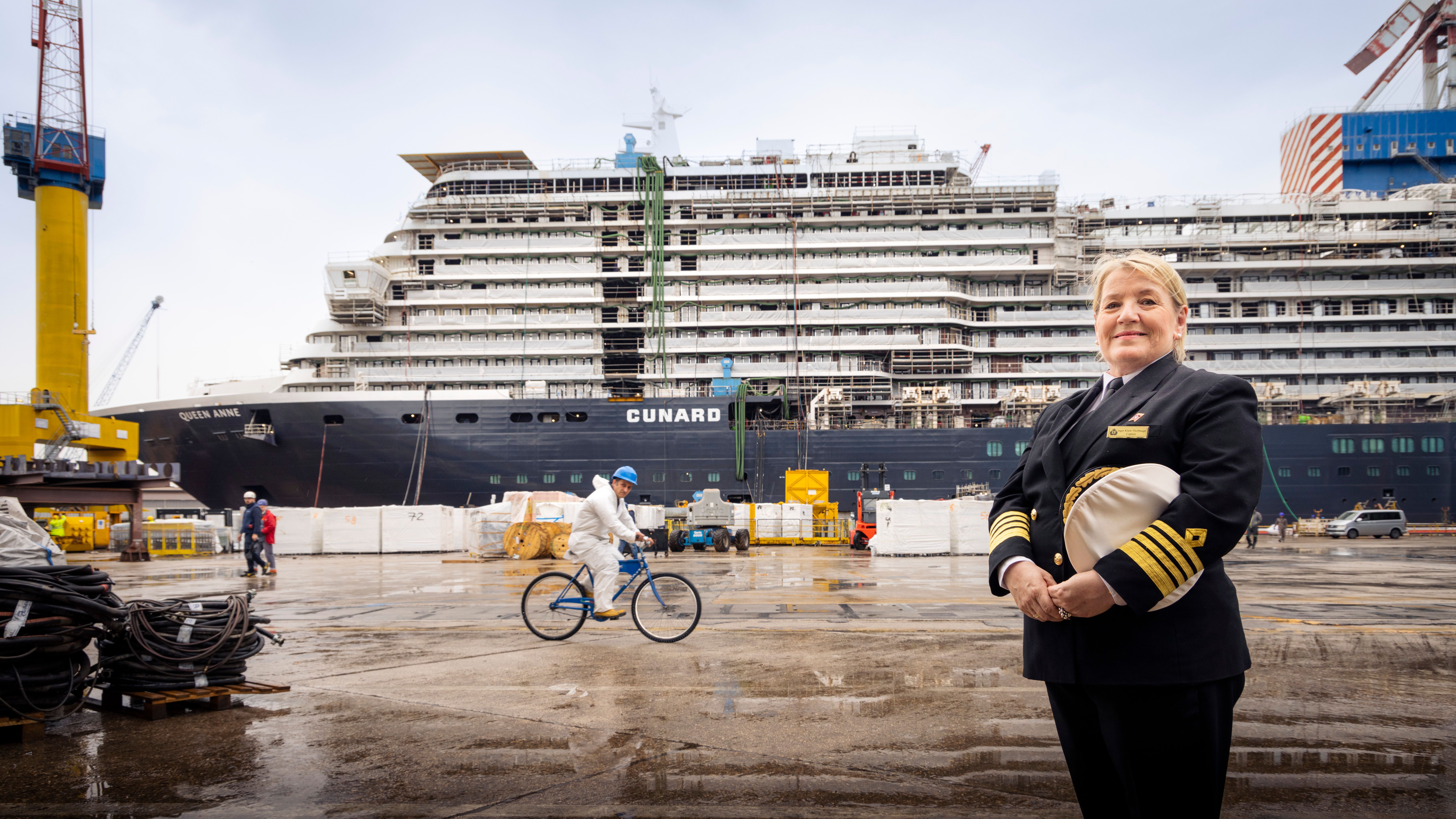 Captain Inger Klein Thorhauge stands proudly in front of the Cunard Queen Anne during construction.