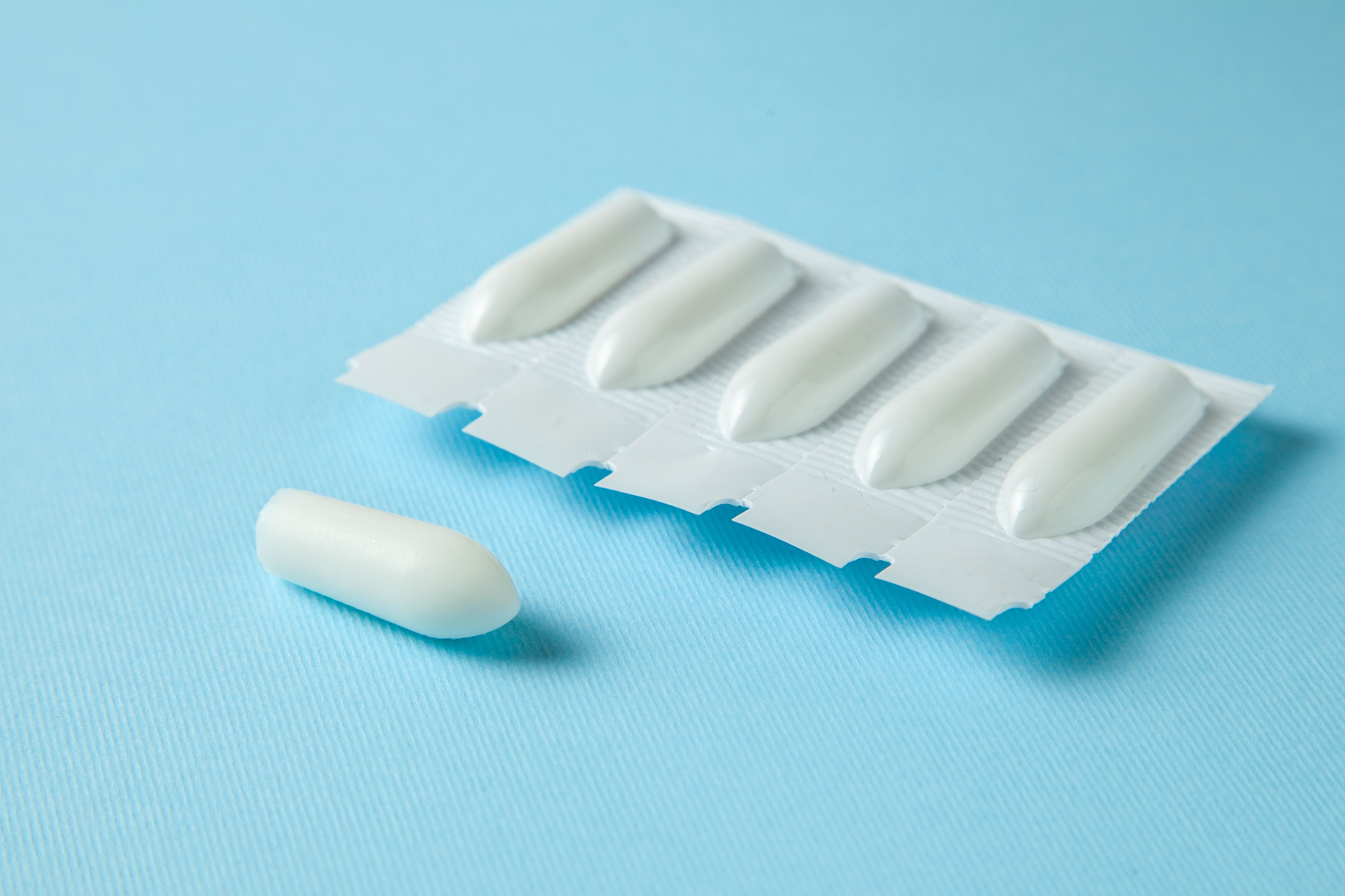 Prochlorperazine suppositories for motion sickness on a cruise, shown as one suppository outside its blister pack against a blue background, focusing on effective seasickness treatment.