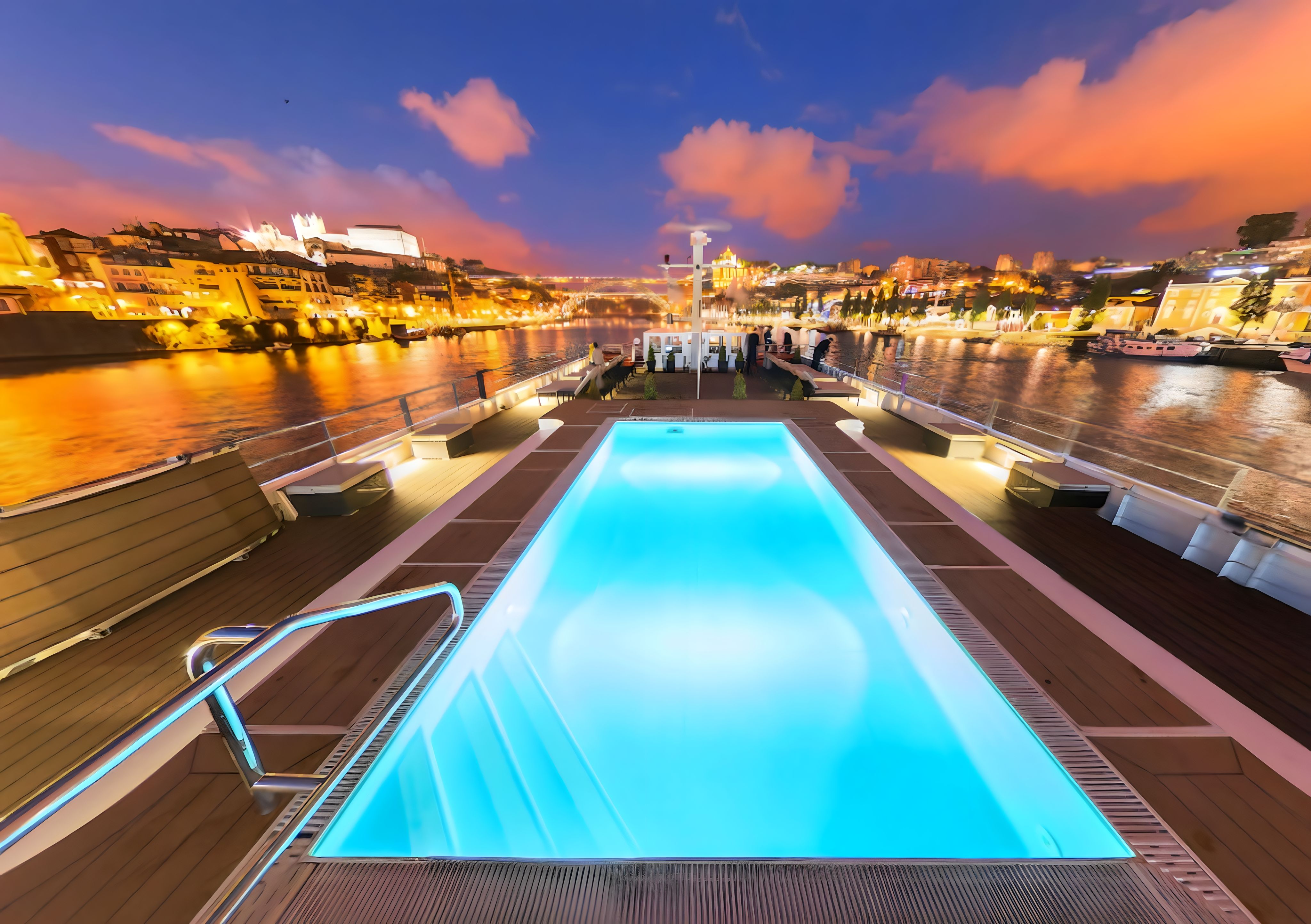 Illuminated pool on Viking river cruise ship with a stunning night view of the Douro River and Porto cityscape.