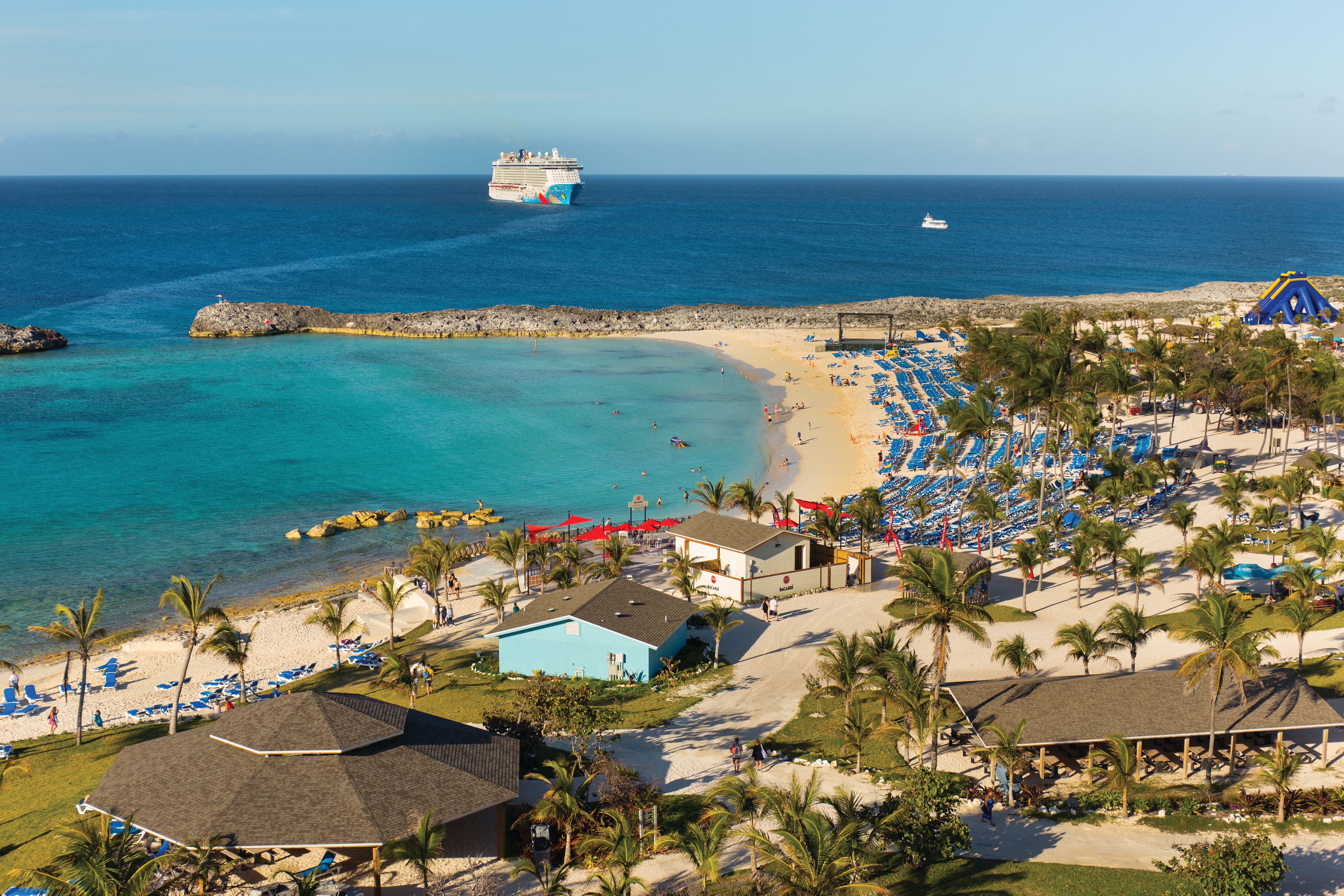 Great Stirrup Cay beach with sun loungers, cabanas, and a cruise ship in the background, an exclusive stop for Norwegian Cruise Line.