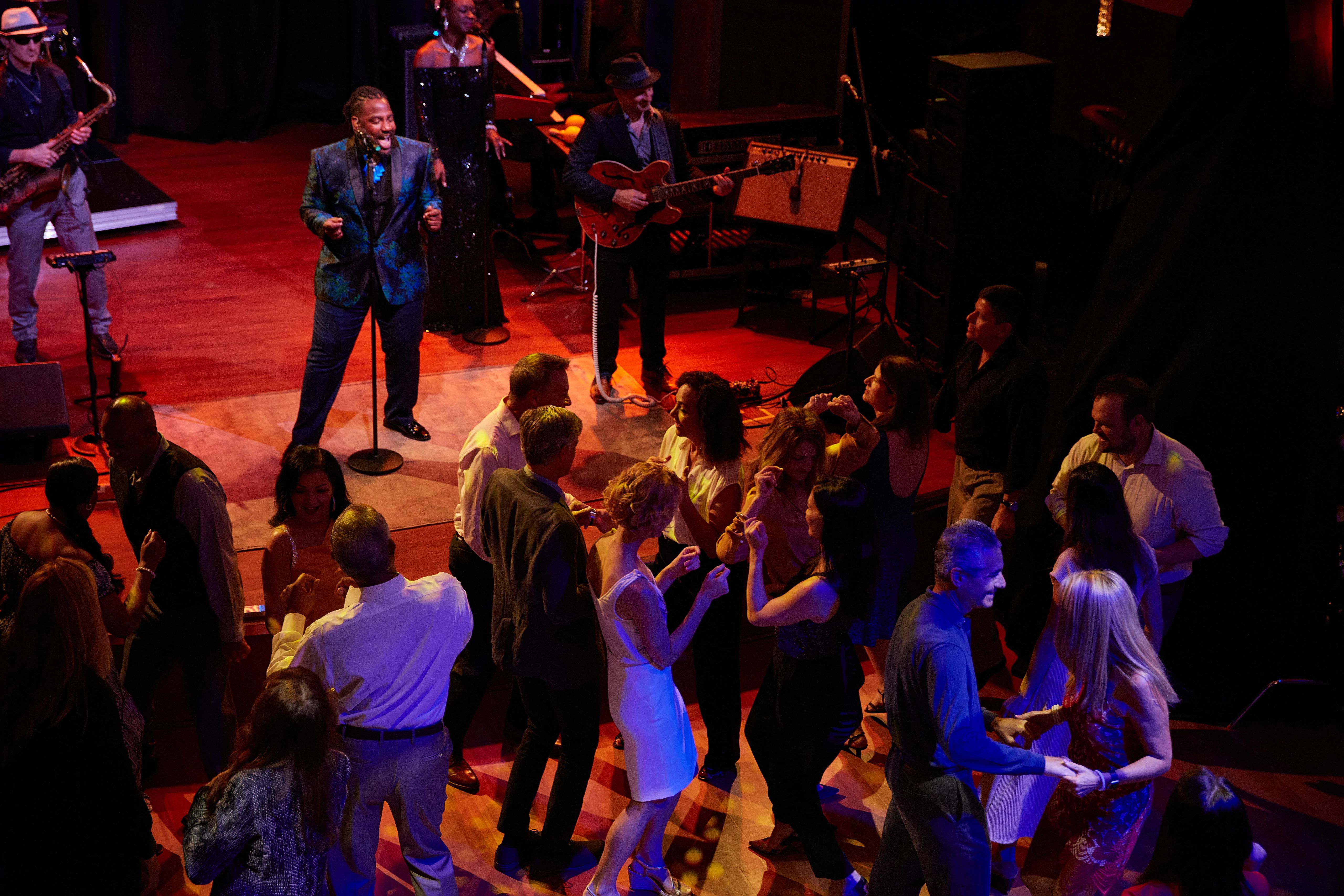 Passengers dancing to live music on a cruise ship, vibrant nightlife entertainment.