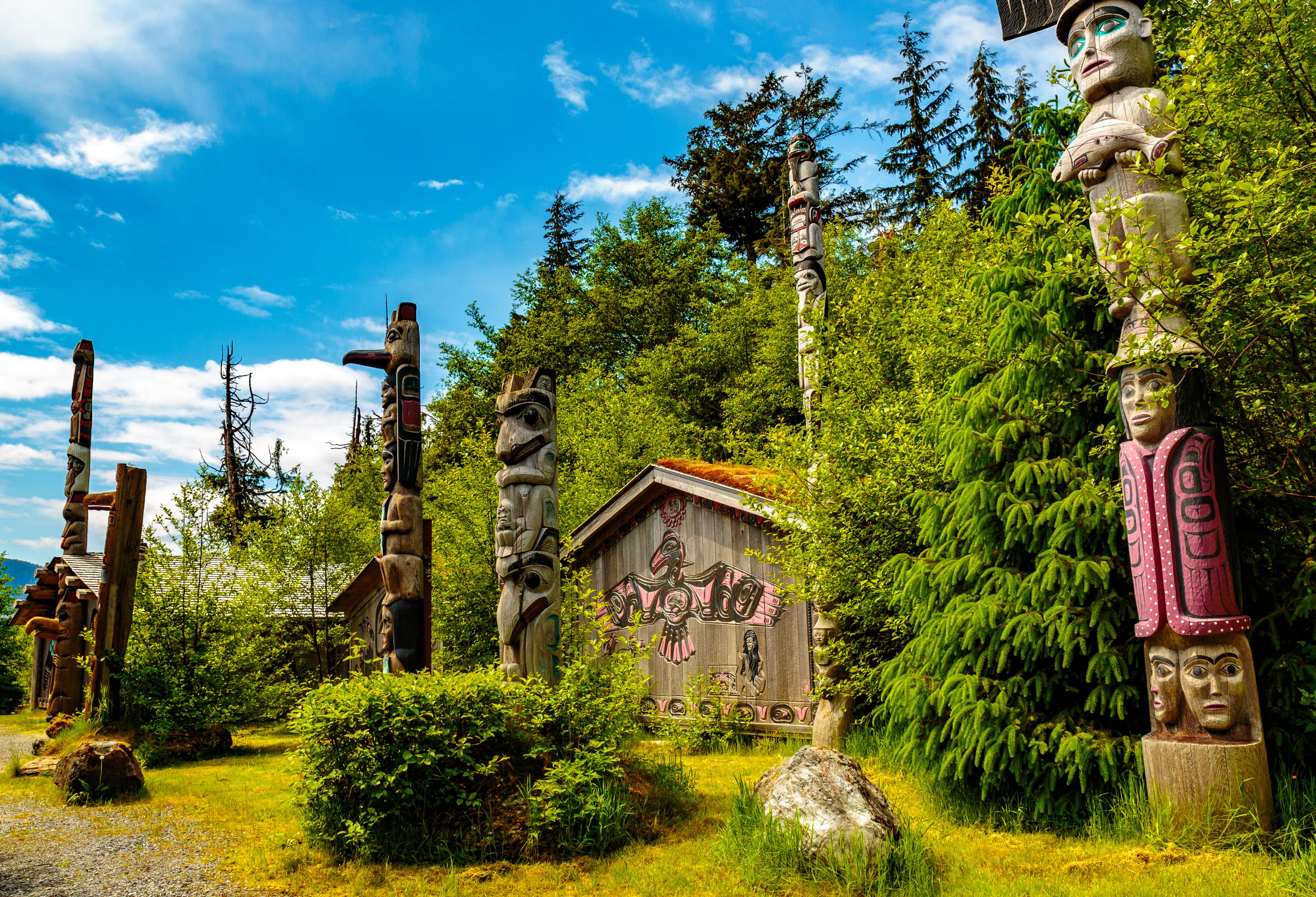 Colorful totem poles and a traditional Native American building in Ketchikan, Alaska, a common cruise destination.