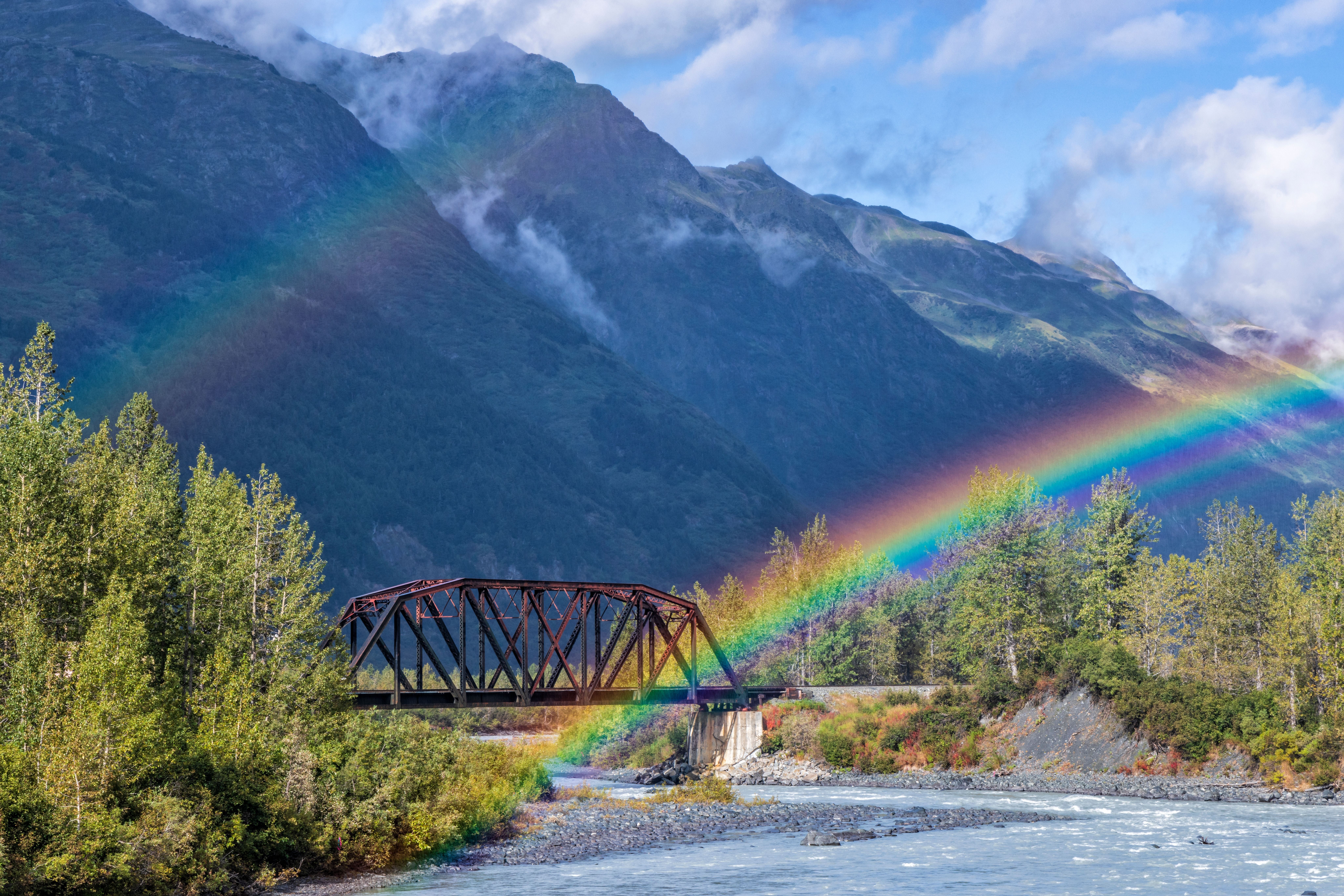 Rainbow over a scenic river and bridge in Chugach National Forest, Alaska, viewed from a cruise shore excursion.