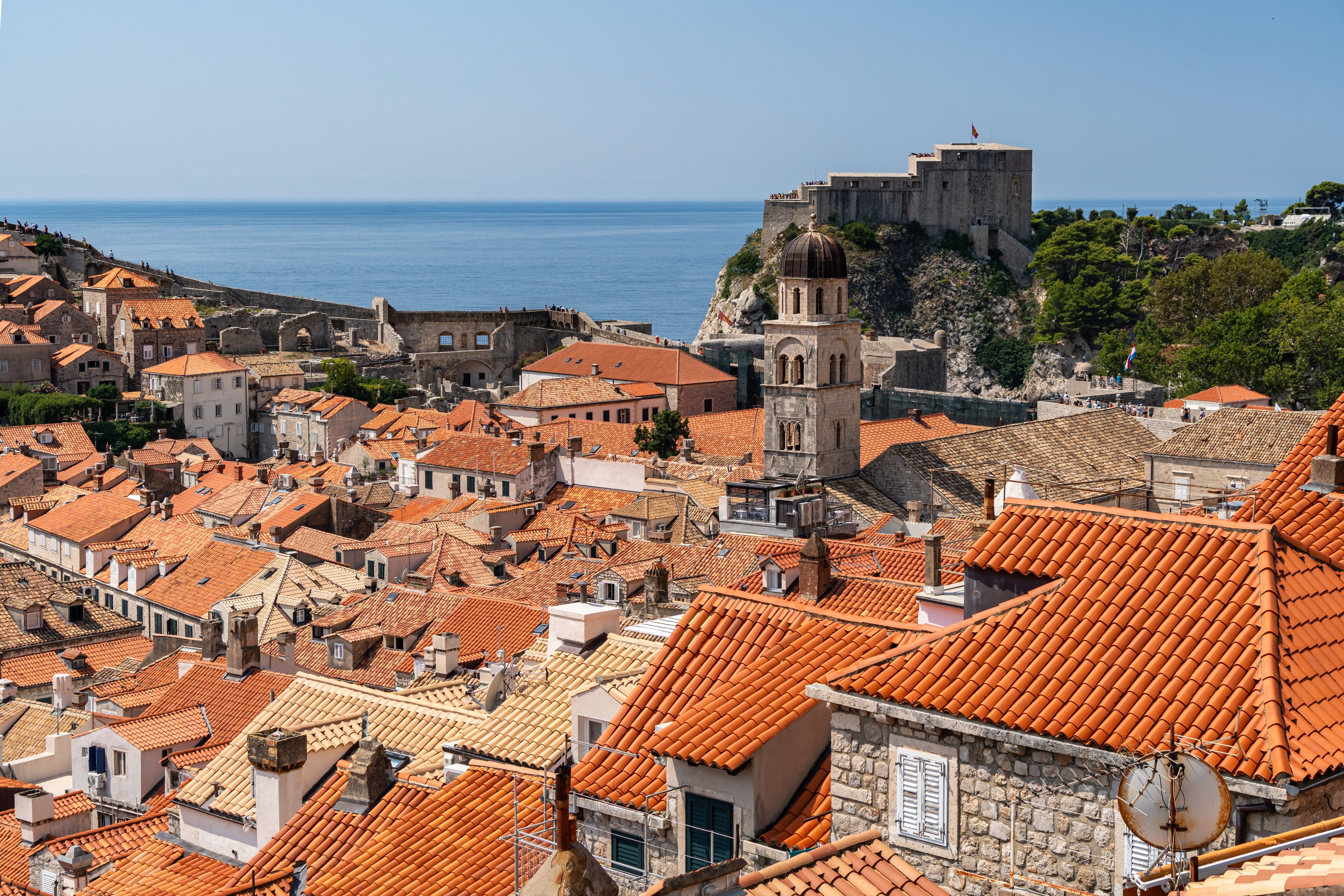 Discover Dubrovnik's historic charm on a walking tour through its iconic red-roofed buildings and ancient city walls, with stunning sea views.