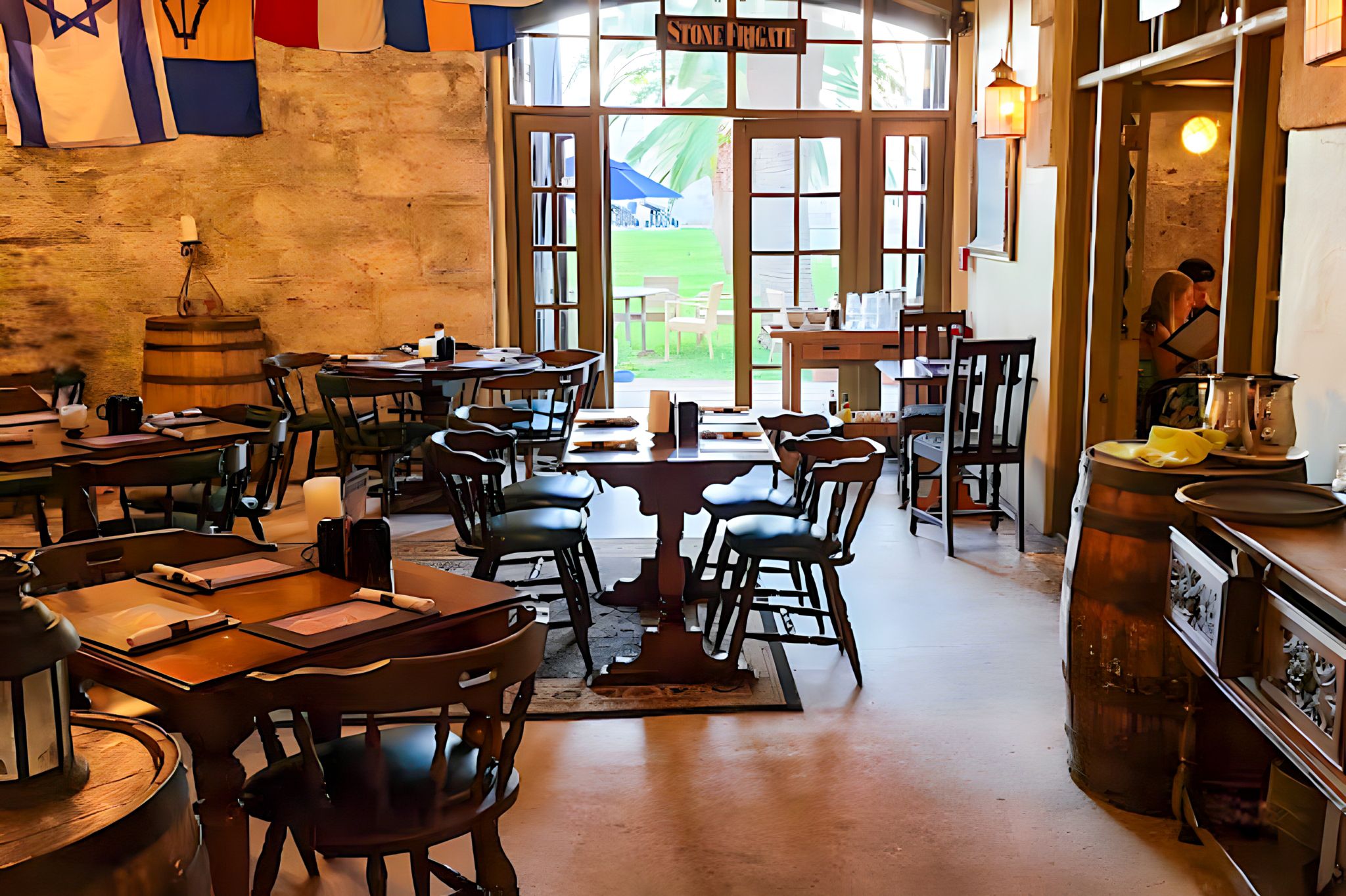 A cozy, historic restaurant in Bermuda with rustic wooden tables, nautical flags, and candlelit decor, offering an inviting atmosphere for local dining.