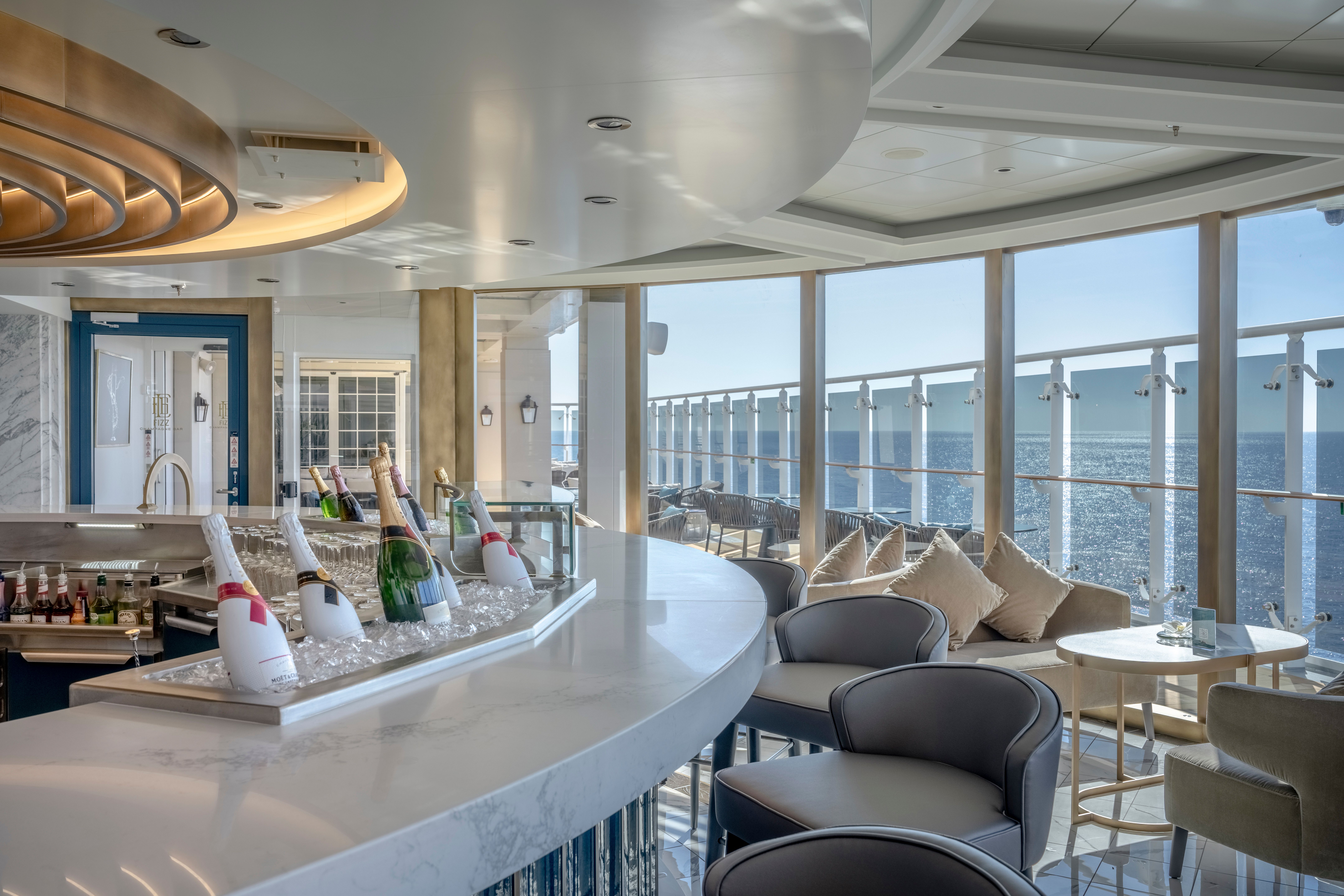 Fizz Champagne Bar on MSC World America, an elegant venue featuring premium bubbly, a sleek marble bar, plush seating, and stunning ocean views for a luxurious experience.