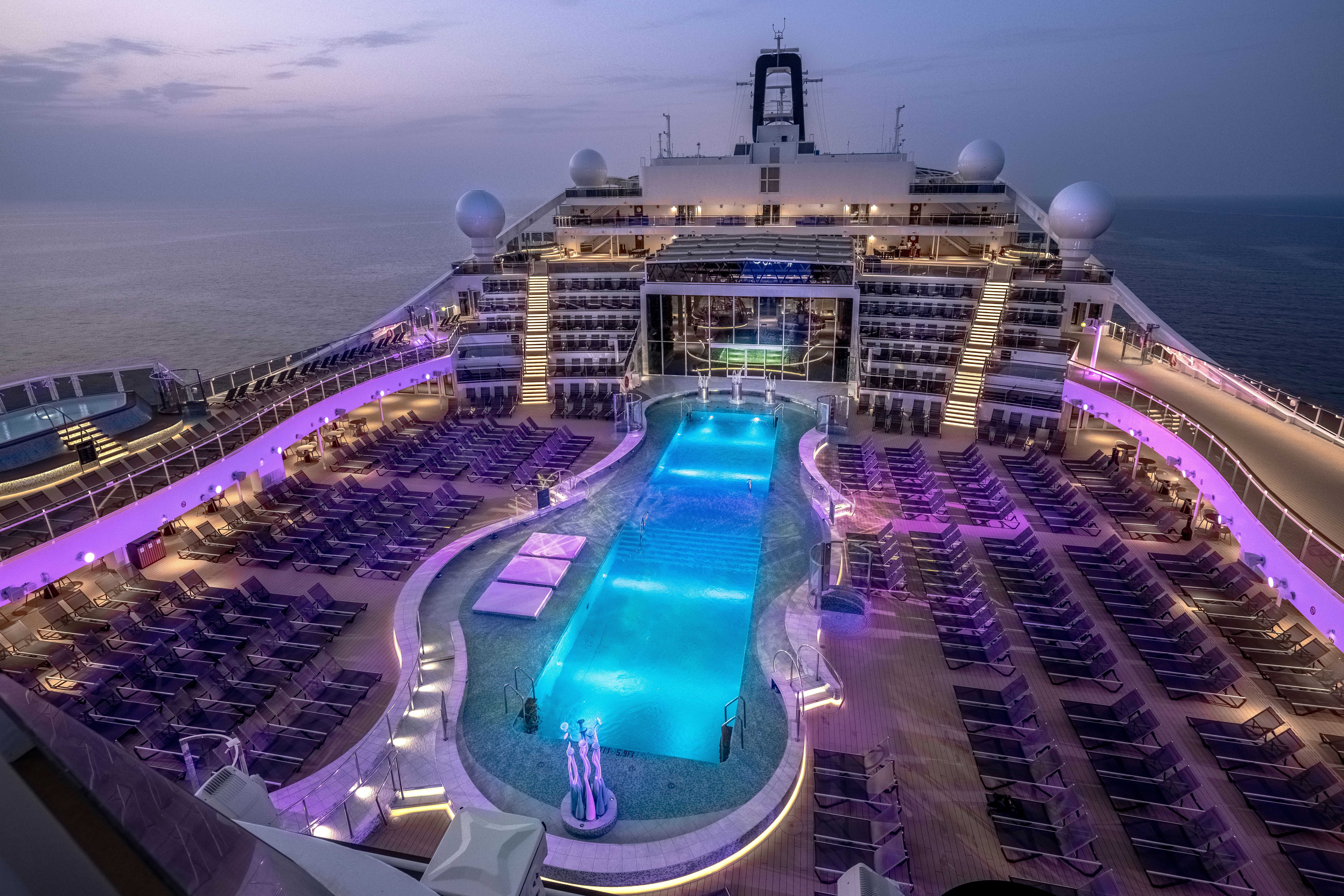 MSC World America La Plage Pool, the ship’s main outdoor pool area, featuring spacious sun loungers, vibrant lighting, and breathtaking ocean views.