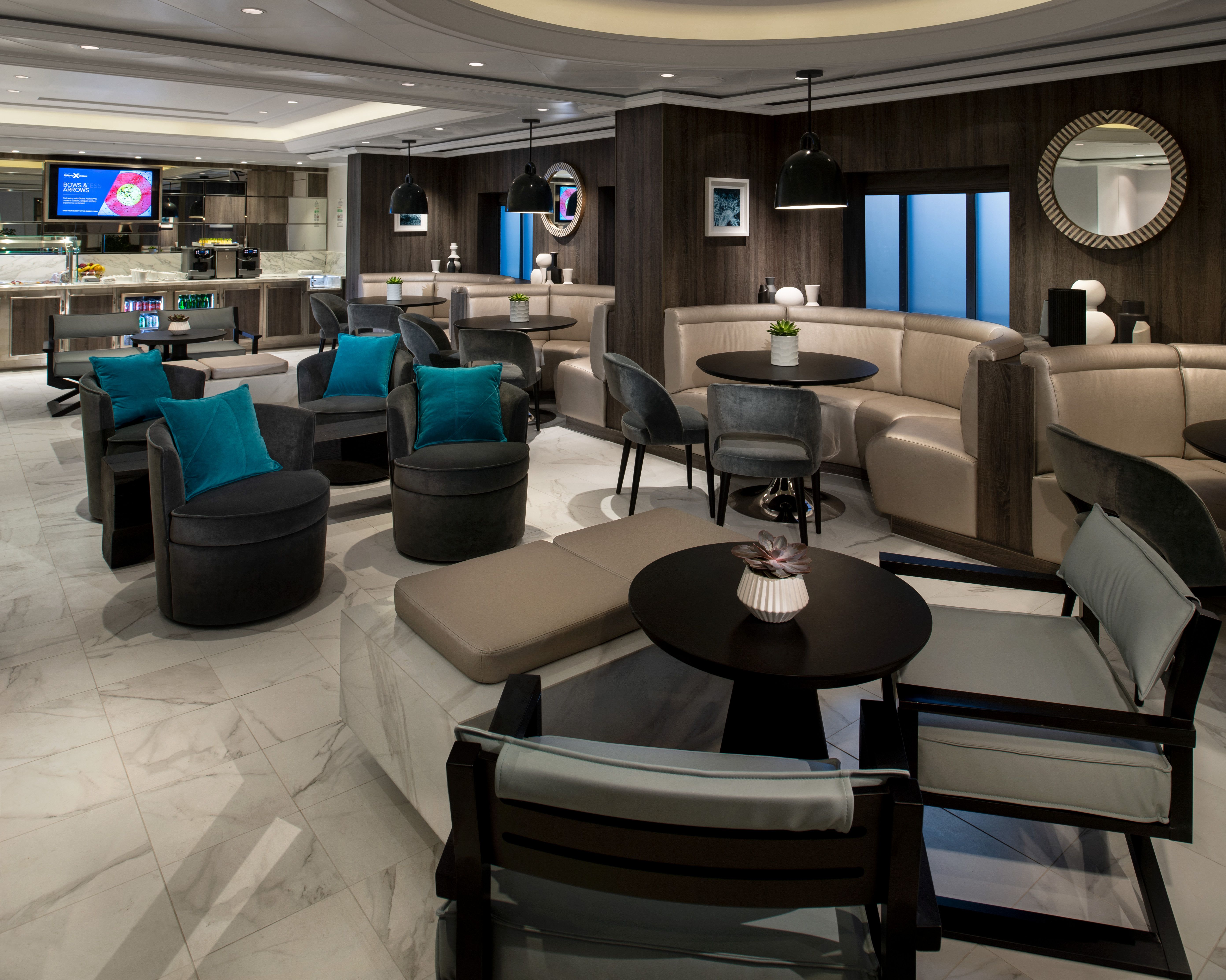 Retreat Lounge on Celebrity Equinox with elegant seating, teal pillows, and a stylish bar, offering a luxurious, private space for suite guests.