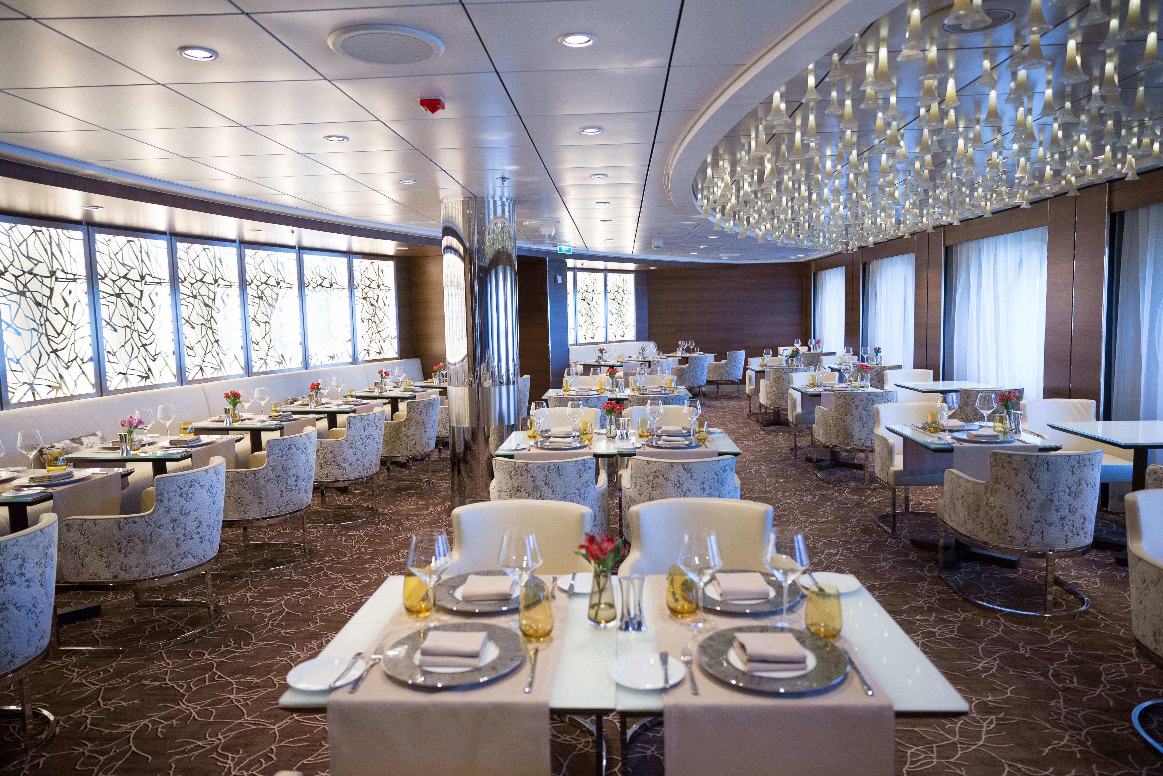 Luminae restaurant on a Celebrity cruise ship with elegant décor, soft lighting, and upscale table settings for suite-class guests.