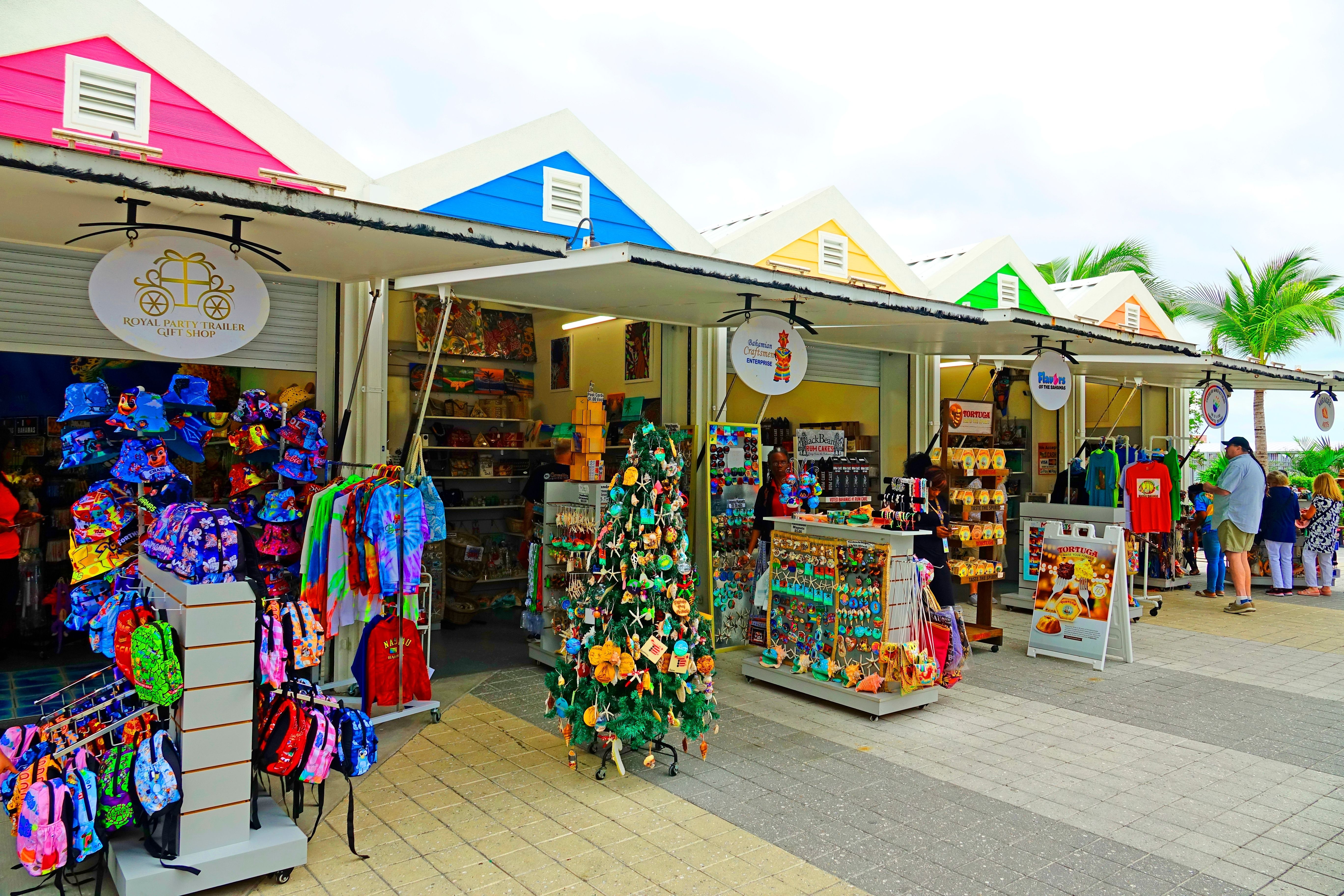 Colorful souvenir shops in Nassau cruise port shopping district offering tropical apparel, handcrafted gifts, and local Bahamian goods near the waterfront.