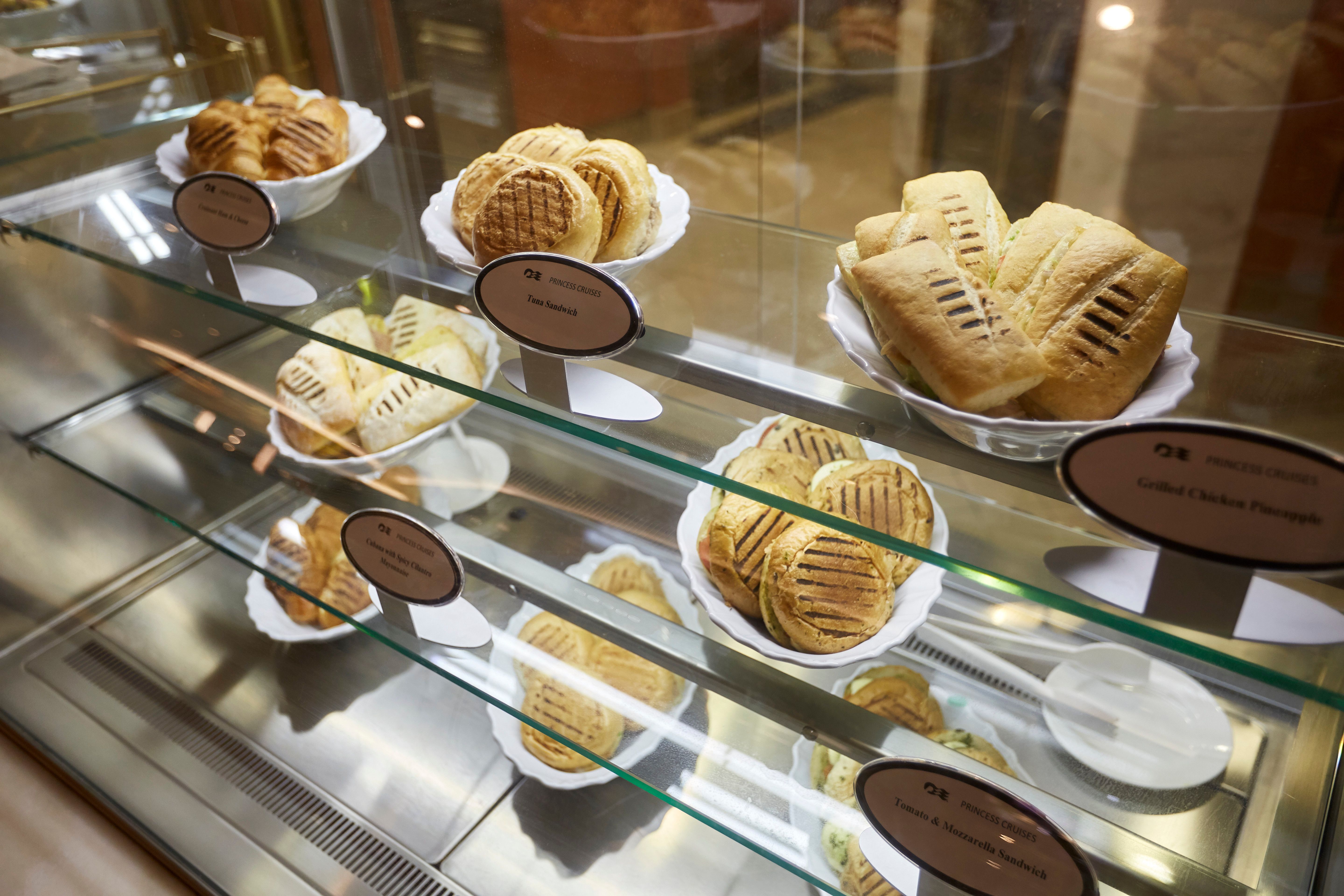Fresh sandwiches and savory pastries on display at Princess Cruises' International Café, a 24-hour venue offering snacks, light bites, and gourmet coffee at sea.