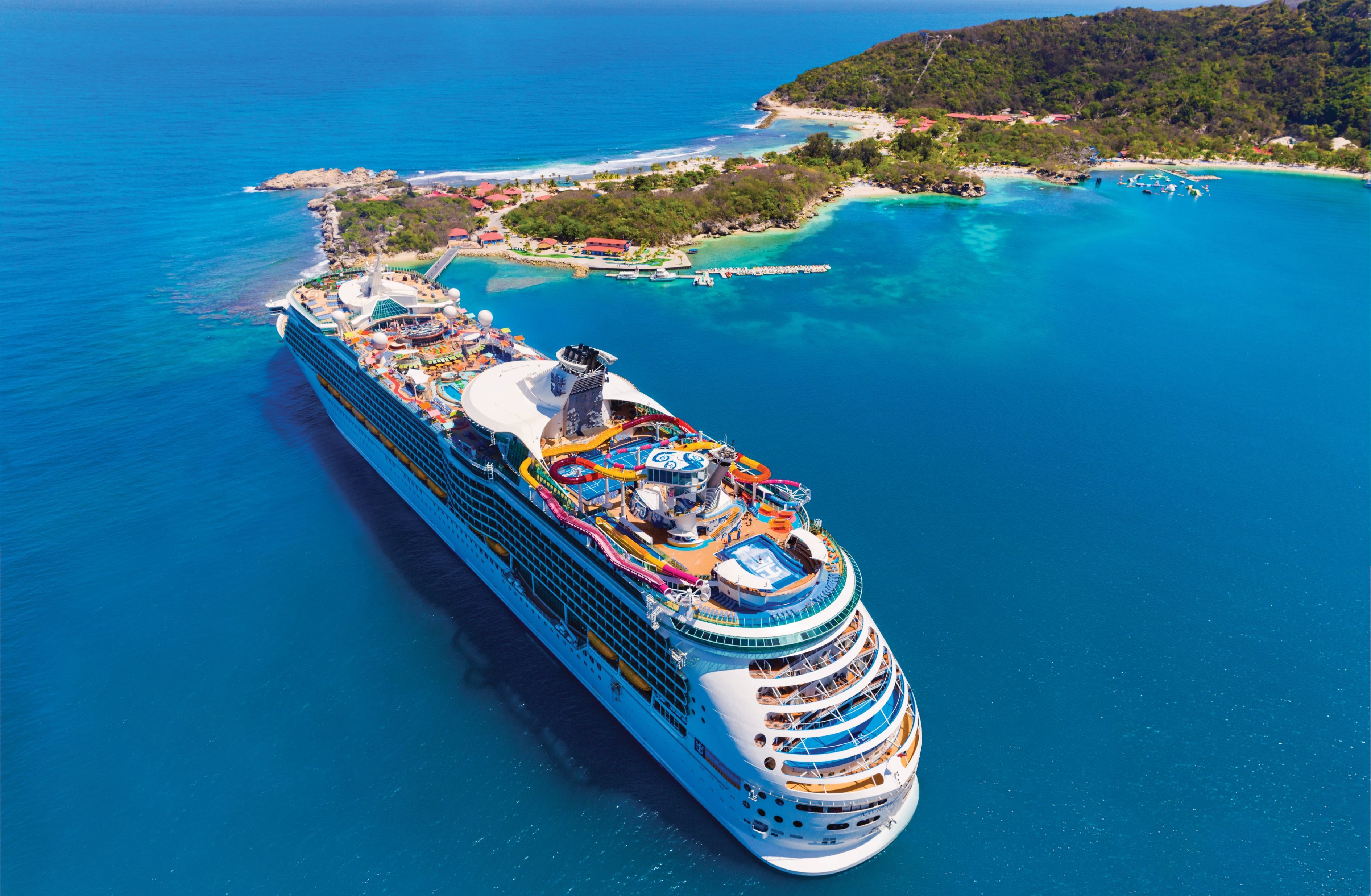 Royal Caribbean's Navigator of the Seas docked at Labadee, Haiti with vibrant water slides and Caribbean coastline in view.