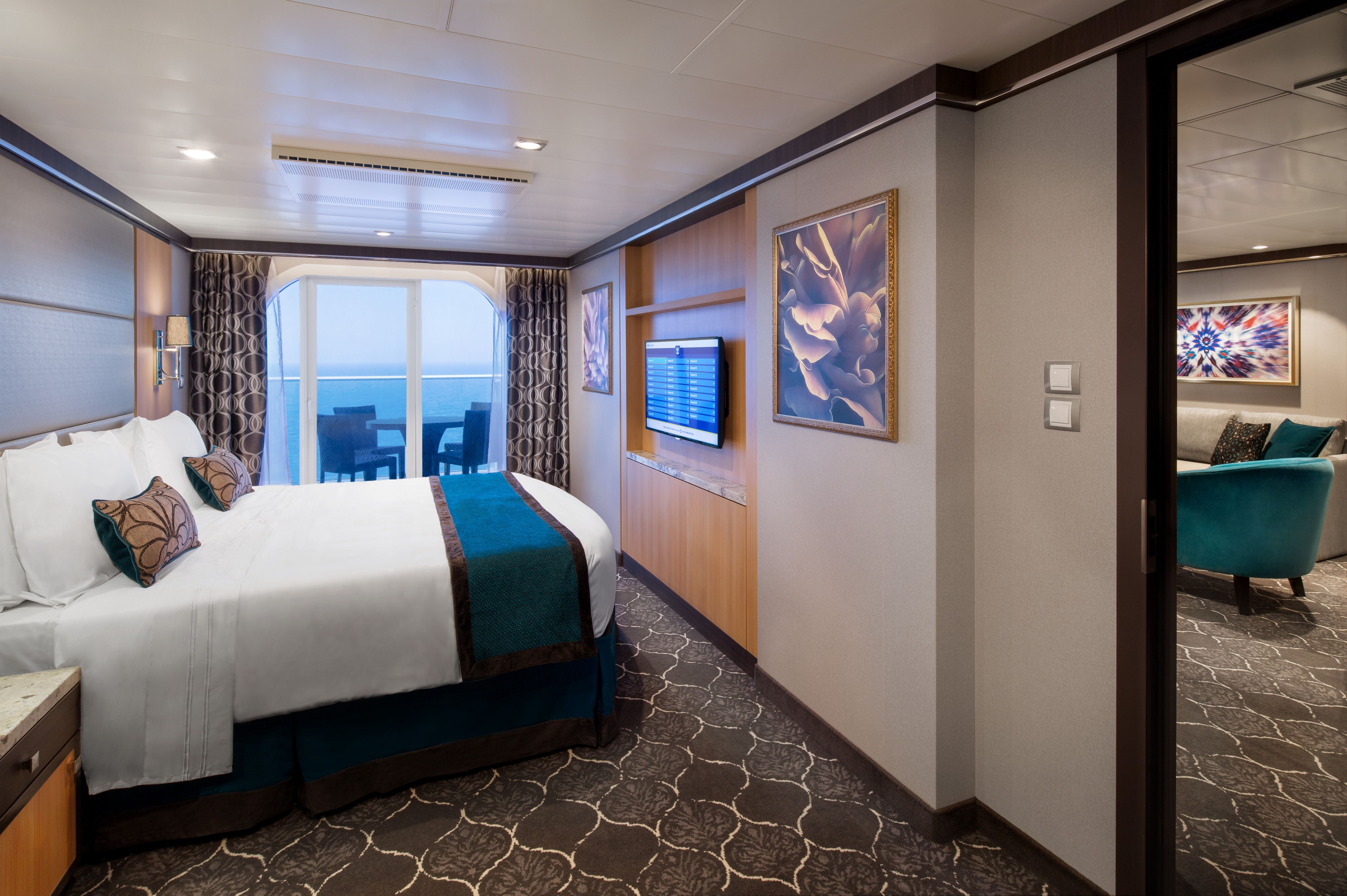 Royal Family Suite on Royal Caribbean with private balcony, king bed, adjoining lounge, flat-screen TV, and modern, elegant décor for multi-guest comfort.