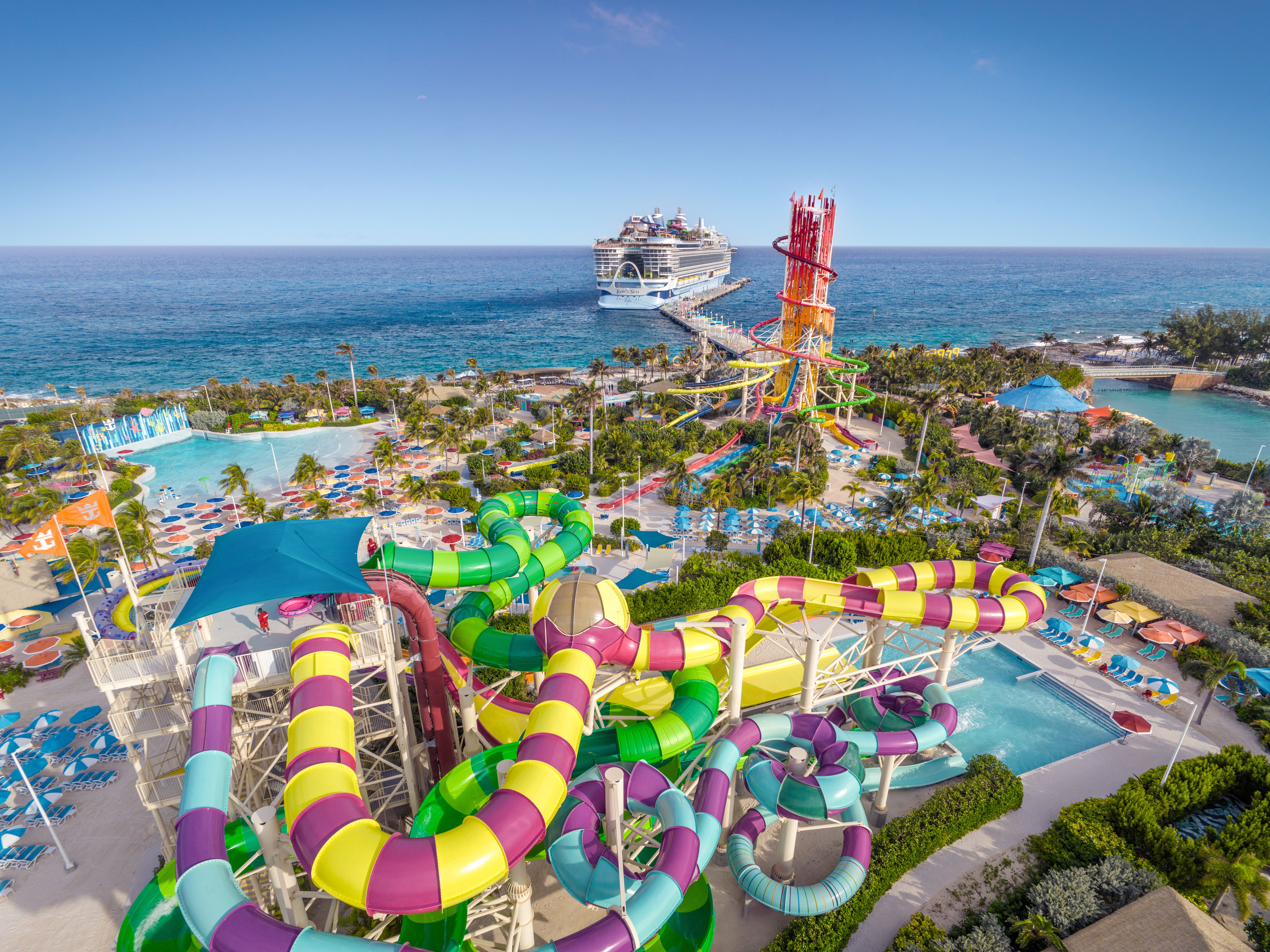 Aerial view of Royal Caribbean’s Perfect Day at CocoCay with vibrant water slides, wave pools, and a docked cruise ship in the Bahamas.