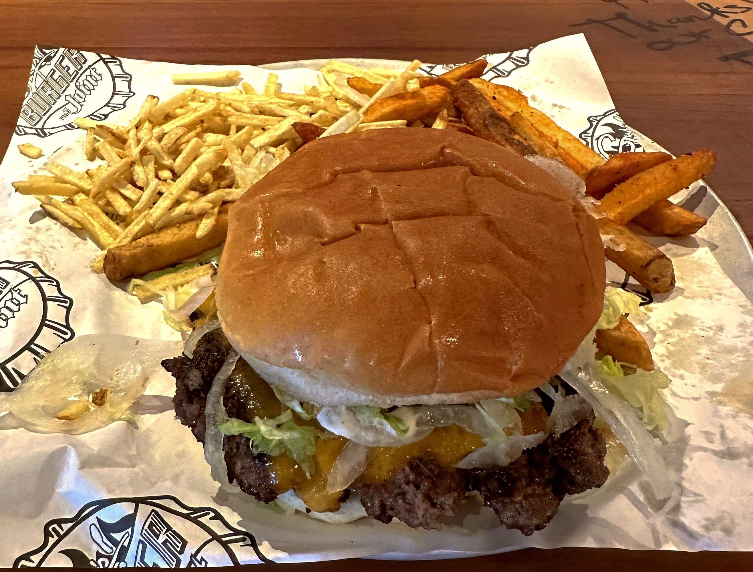 Burger with fries served at Guy’s Burger Joint on Carnival Cruise Line, known for its handcrafted burgers with fresh toppings and crispy fries.