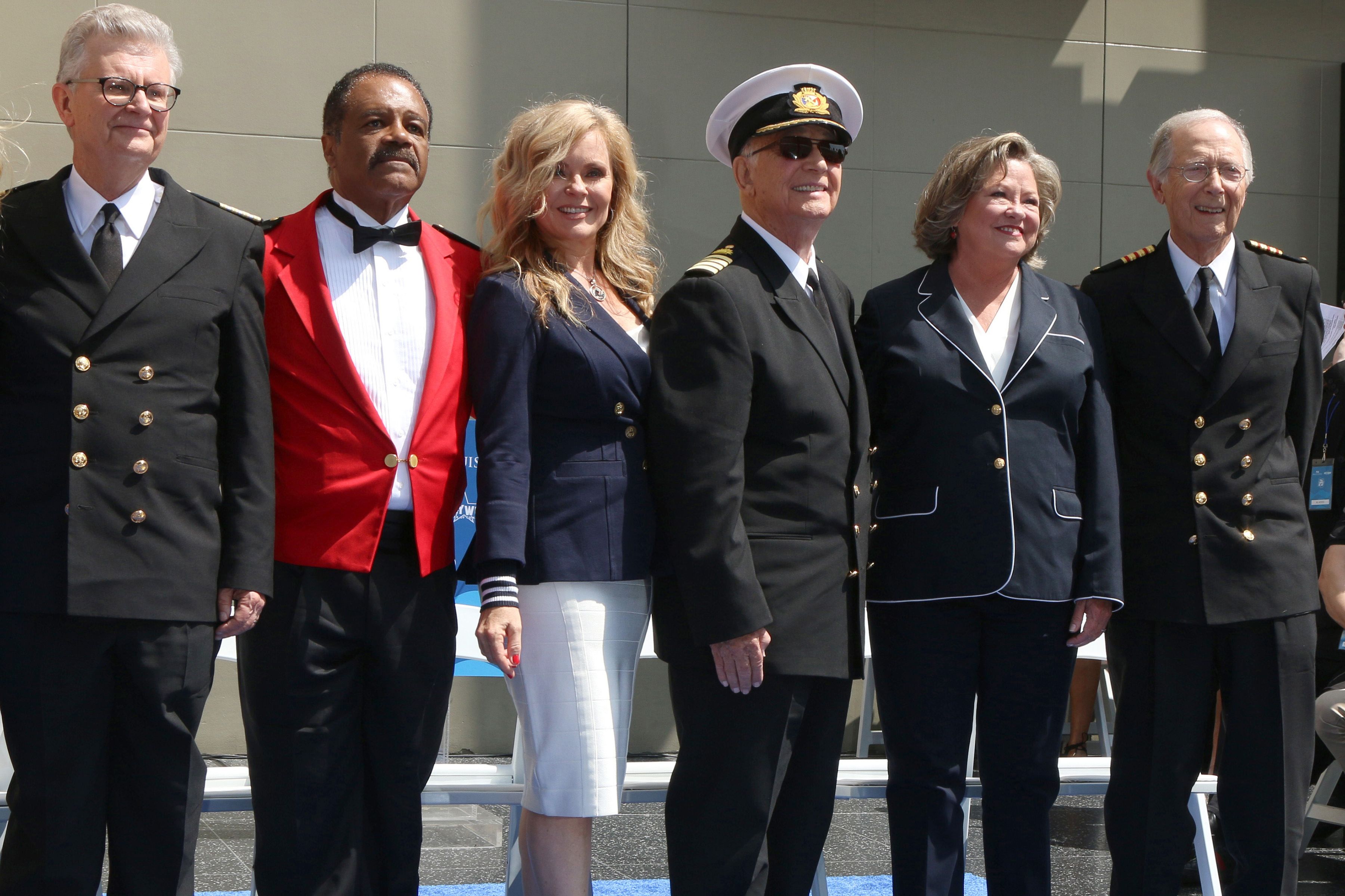The original cast of The Love Boat standing together in uniform at a Hollywood Walk of Fame event under bright daylight.