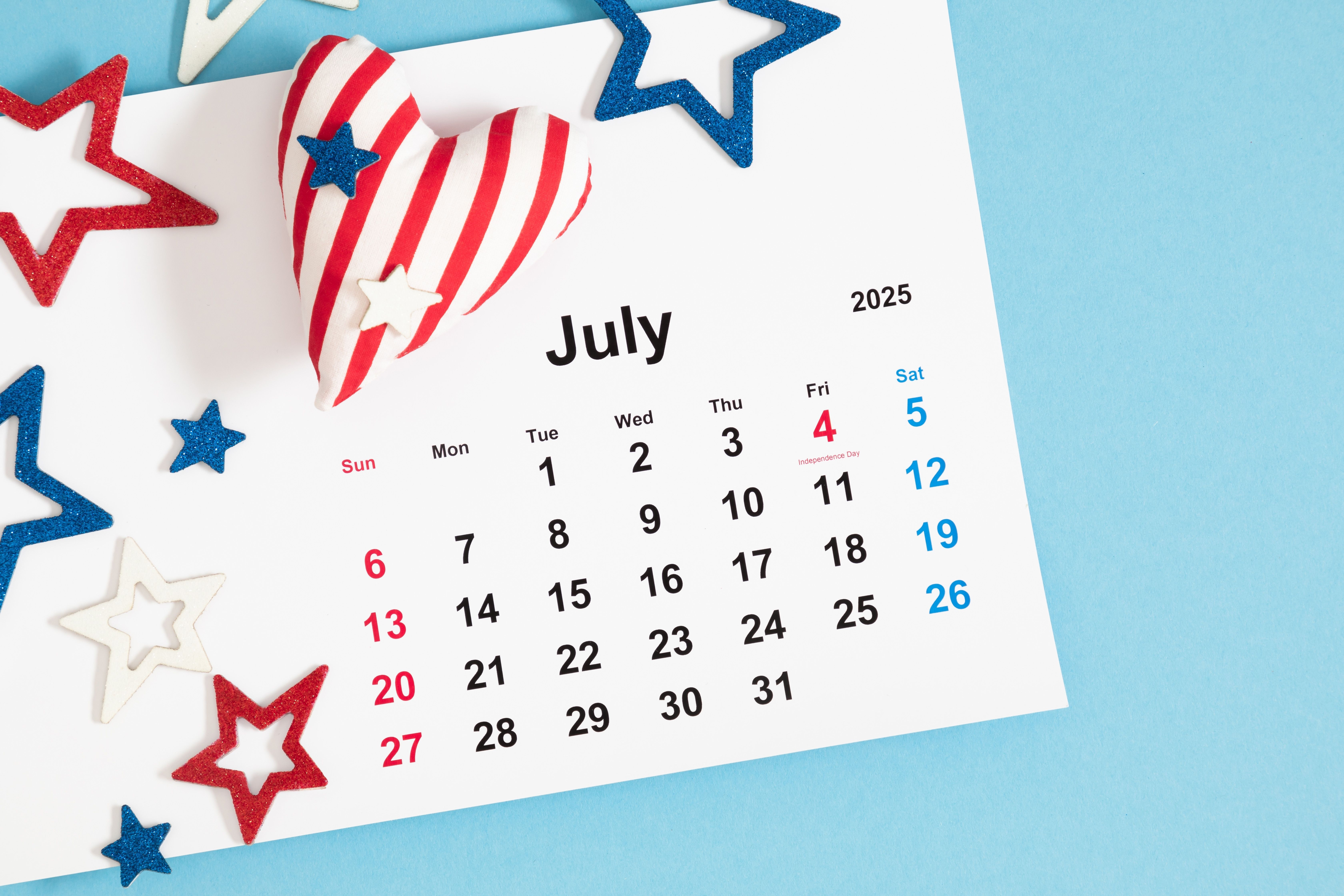 July 2025 calendar with patriotic red, white, and blue stars and heart, highlighting U.S. Independence Day on July 4th. Perfect for summer cruise promotions.