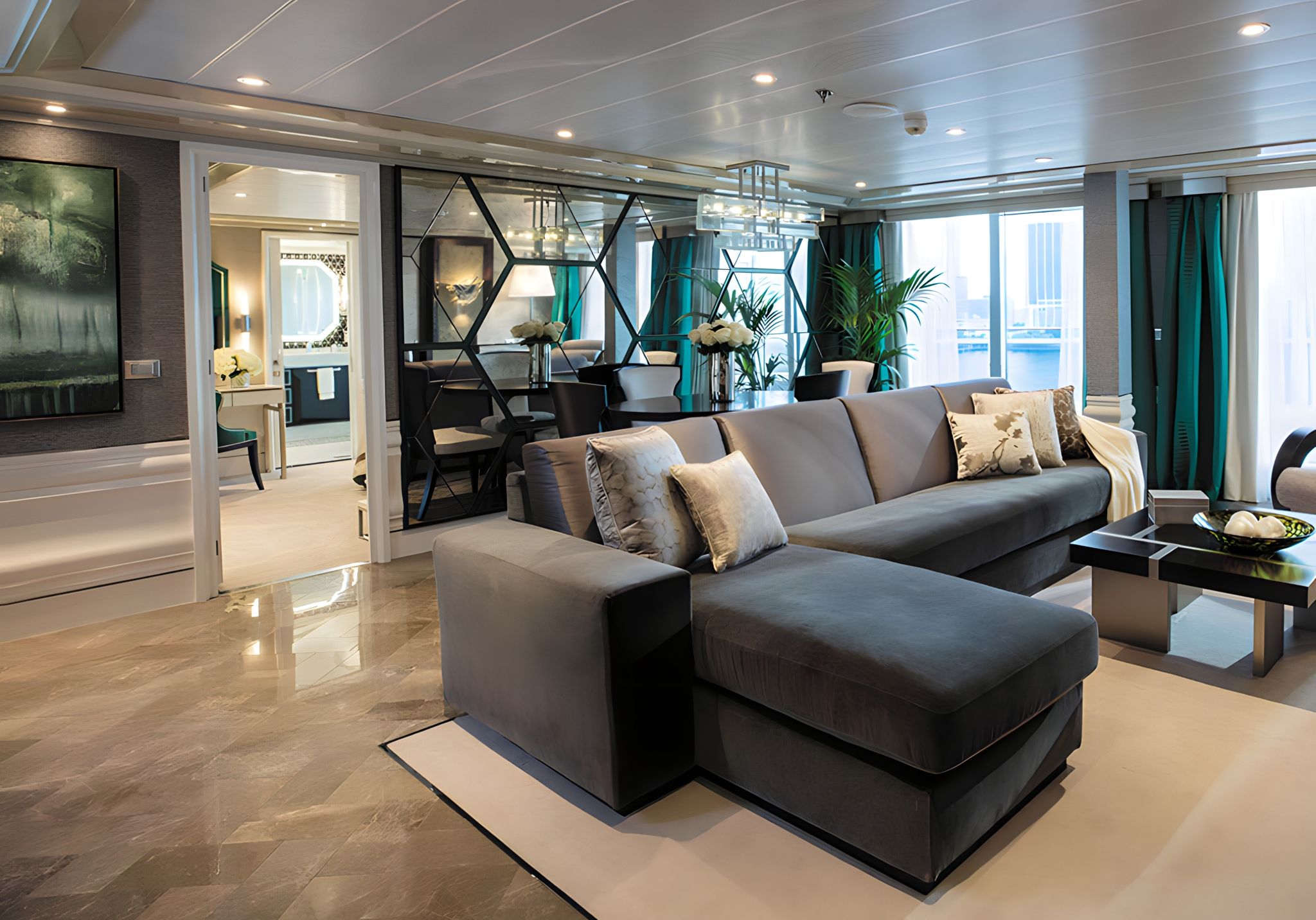 Spacious Grand Suite living room on Seven Seas Splendor with sectional sofa, dining area, and contemporary design accents.