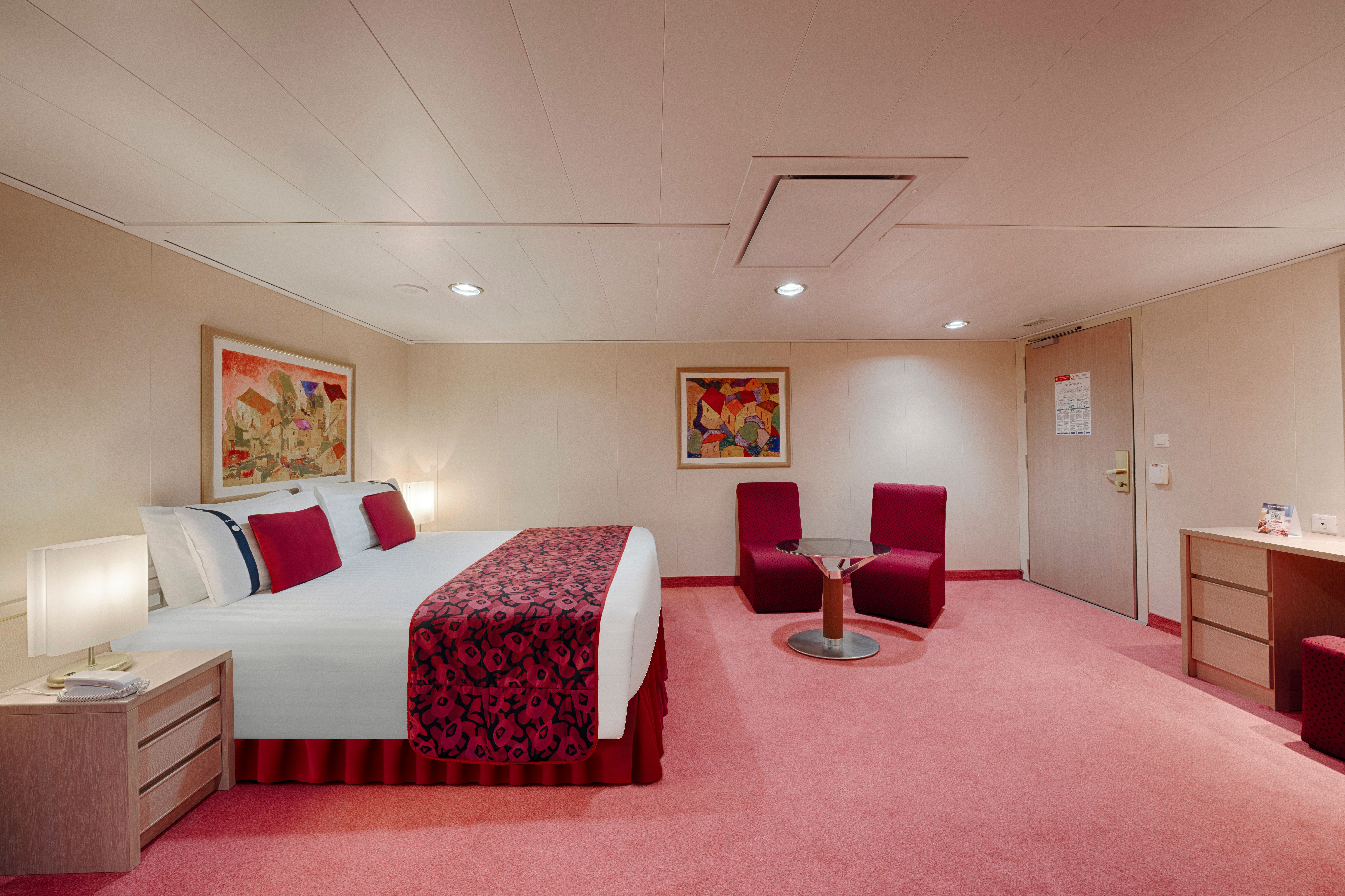 Spacious MSC Orchestra Premium Balcony accessible cabin with king bed, sitting area, and warm décor designed for comfort and mobility needs.