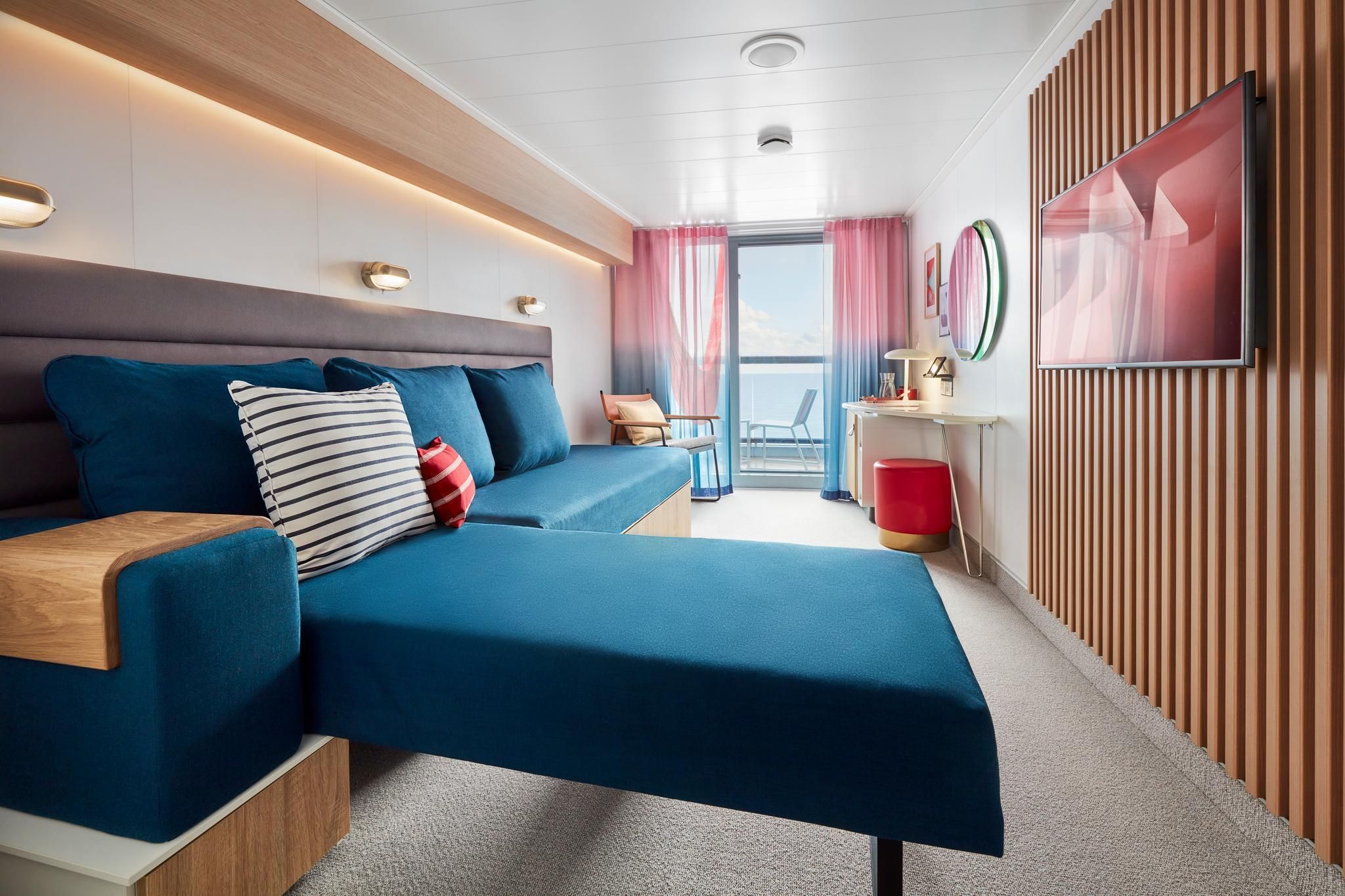 Virgin Voyages Sea Terrace cabin lounge setup with convertible sofa bed and balcony access, smart cruise ship design