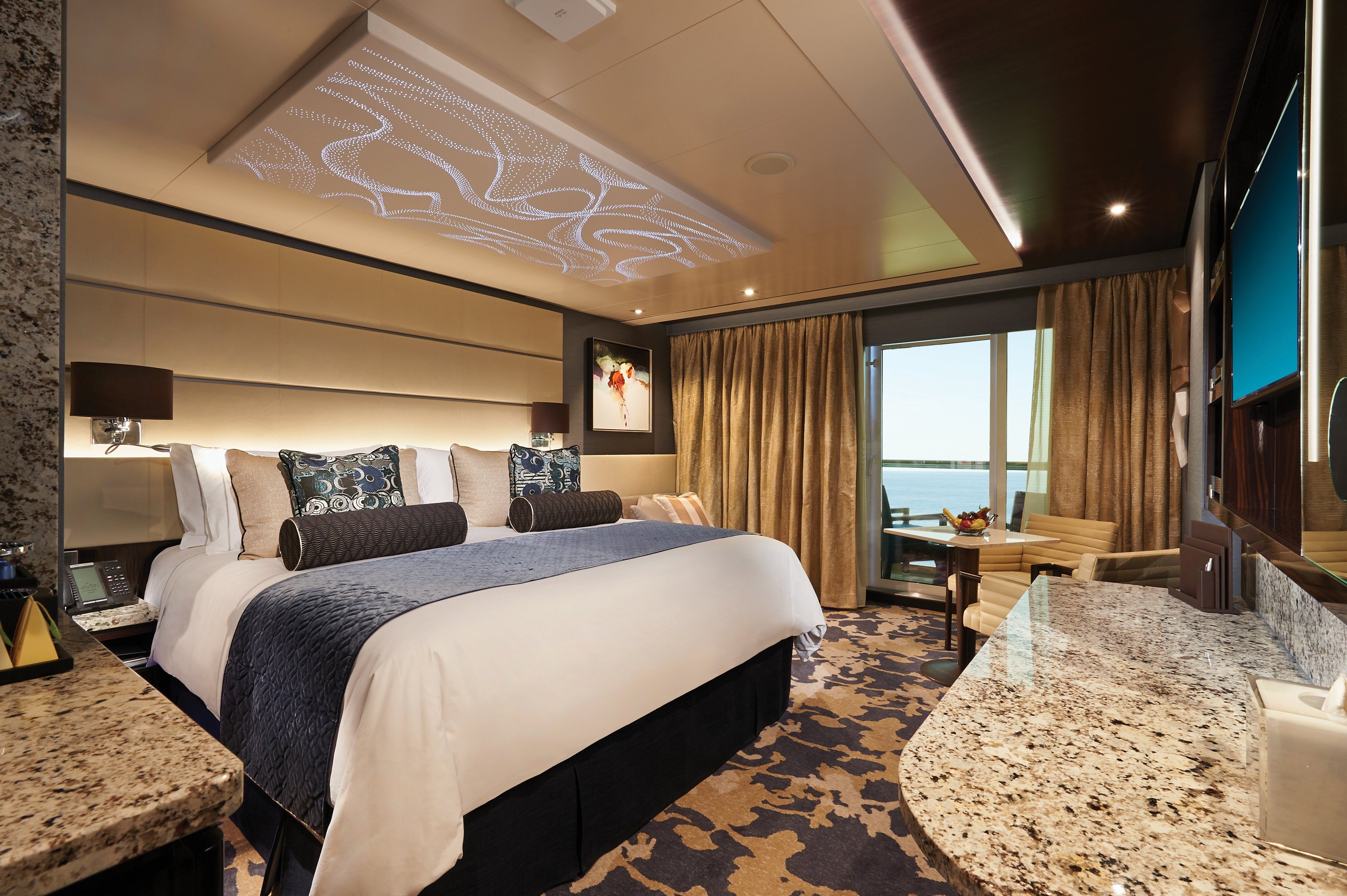 Norwegian Bliss Haven Aft-Facing Penthouse bedroom with king bed, elegant ceiling detail and sliding doors to a private oceanview balcony.