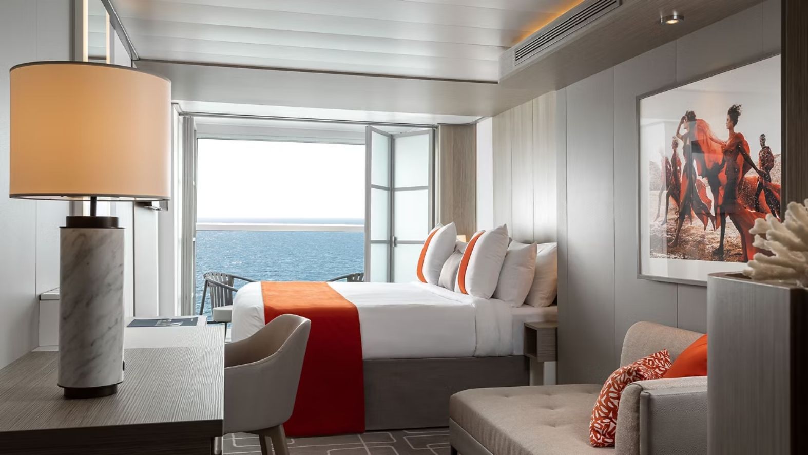 Celebrity Xcel Aqua Class stateroom with king-size bed, orange accents, private veranda with ocean views and modern spa-inspired décor