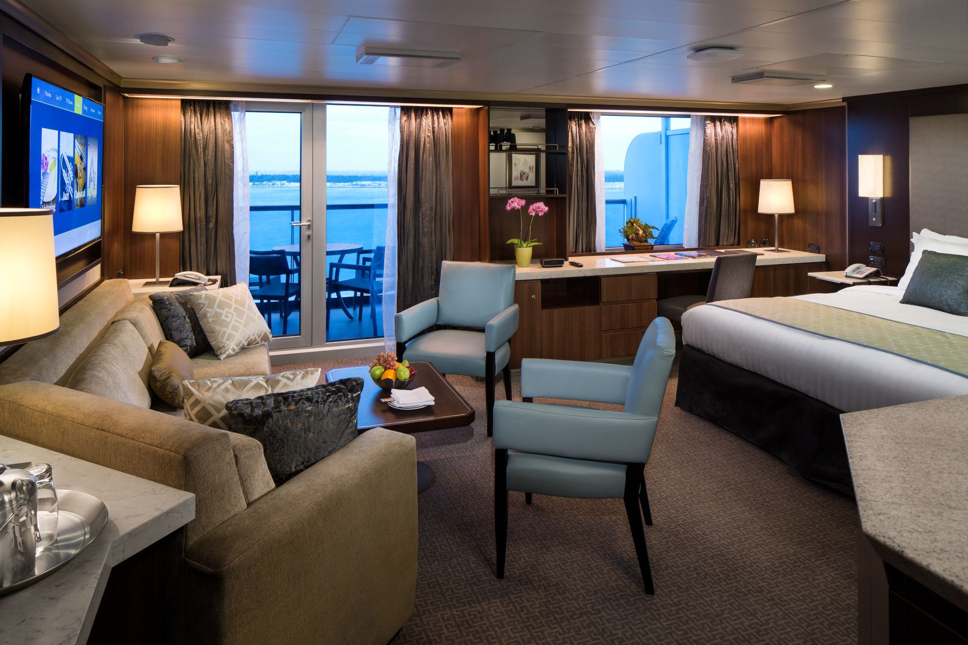 Holland America Line Neptune Suite spacious sitting area with sofa, floor-to-ceiling windows and private veranda access aboard Eurodam cruise ship