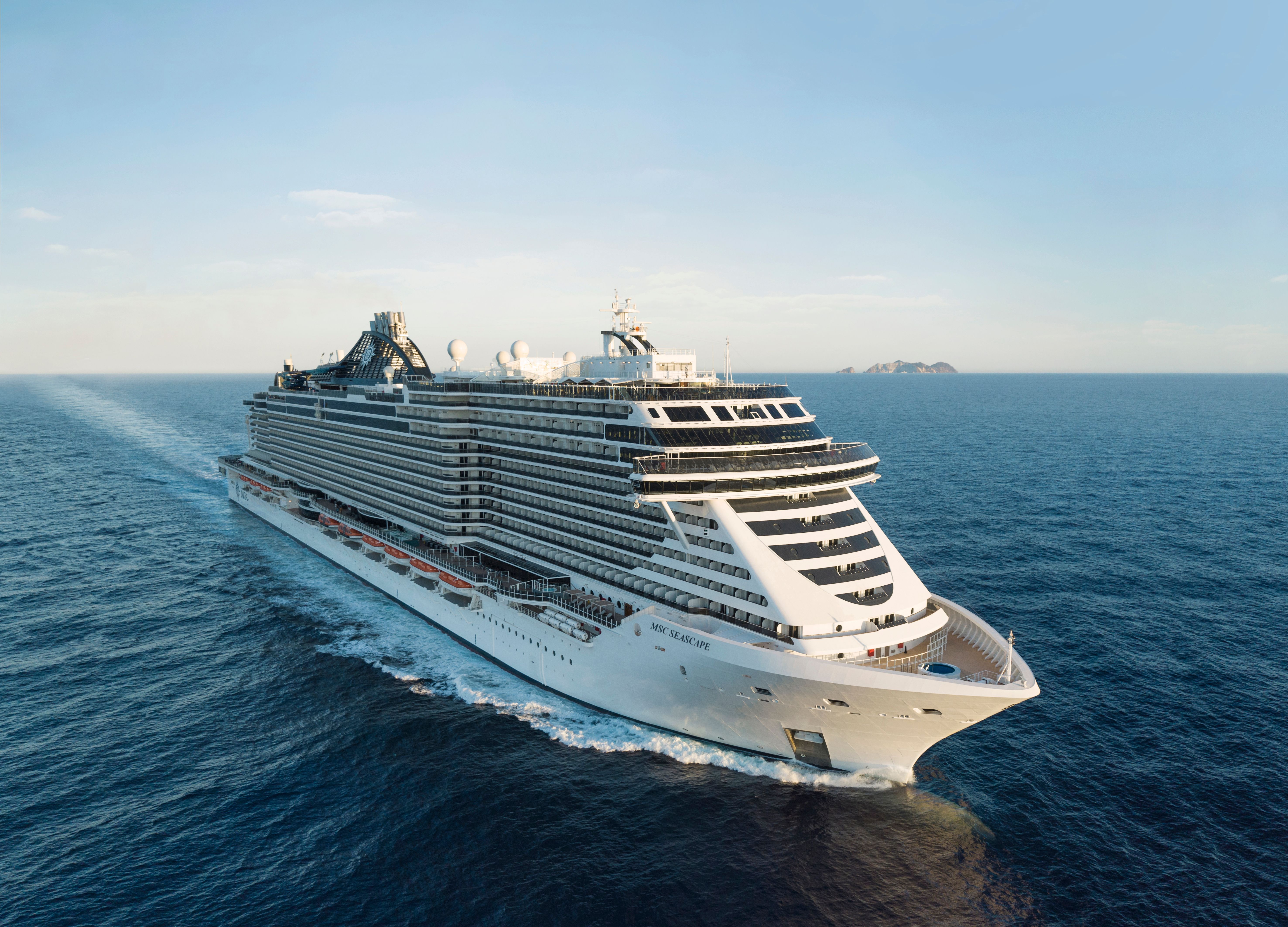 MSC Seascape cruise ship aerial view sailing at sea, modern MSC Cruises vessel with expansive decks, balconies and ocean horizon under clear sky.