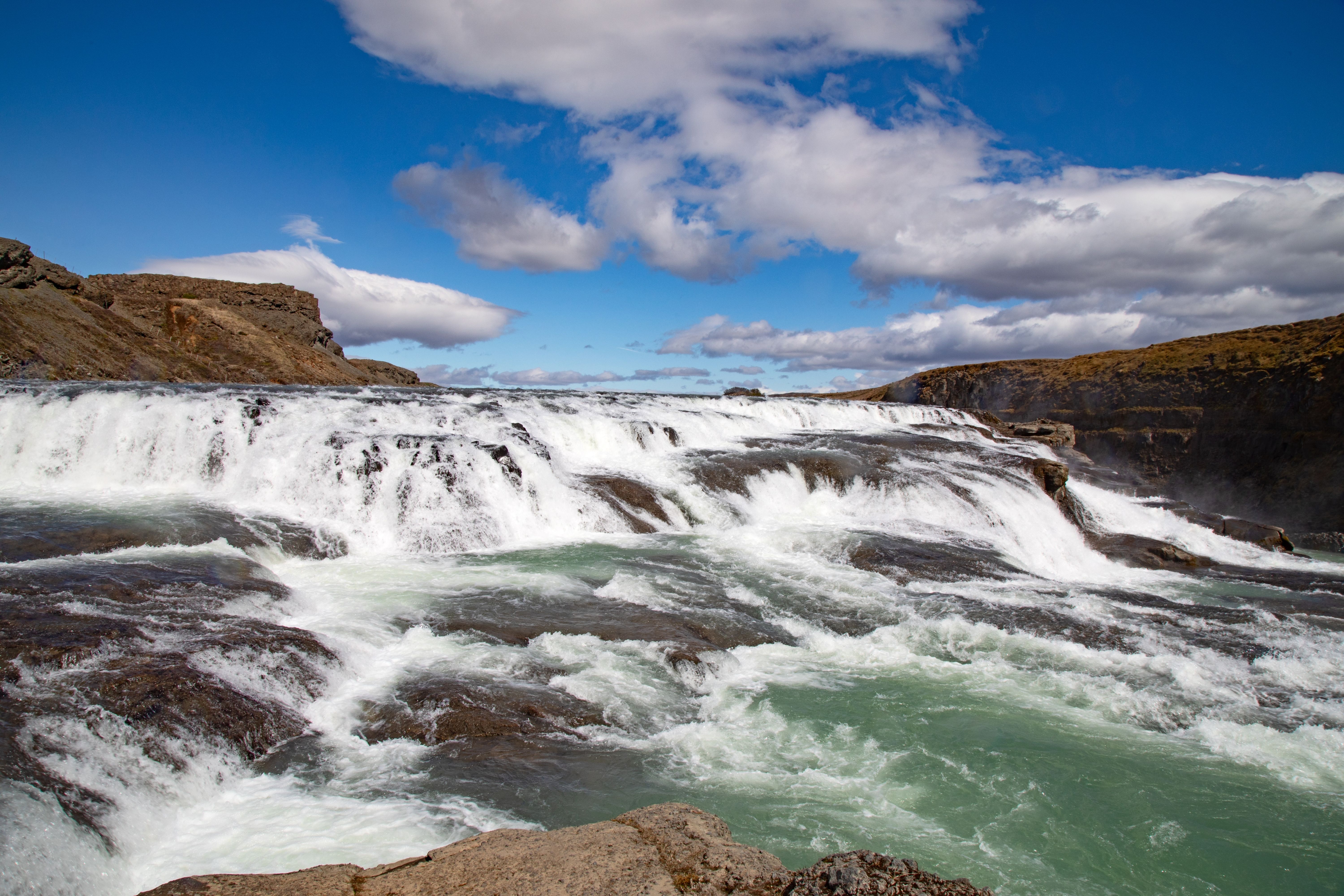 Gullfoss Waterfall in Iceland’s Golden Circle, featuring powerful cascading falls, rugged volcanic terrain, and dramatic skies on a popular shore excursion.